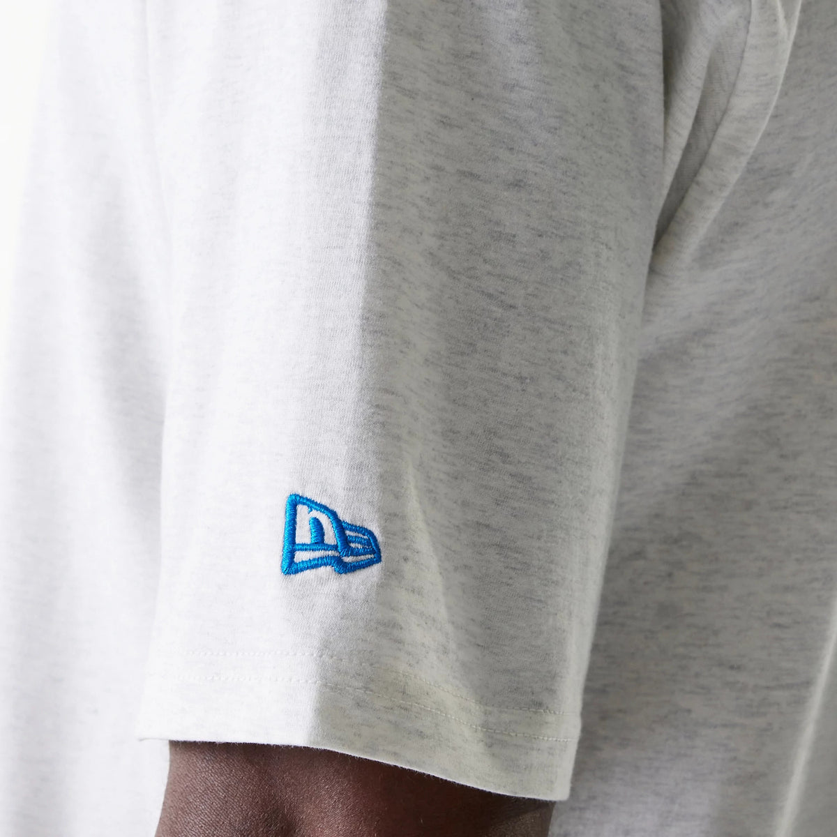 New Era Detroit Tigers MLB World Series Pastel Grey Oversized T-Shirt, side view showing the grey fabric with a blue embroidered New Era logo on the sleeve edge, highlighting the oversized short sleeve design.