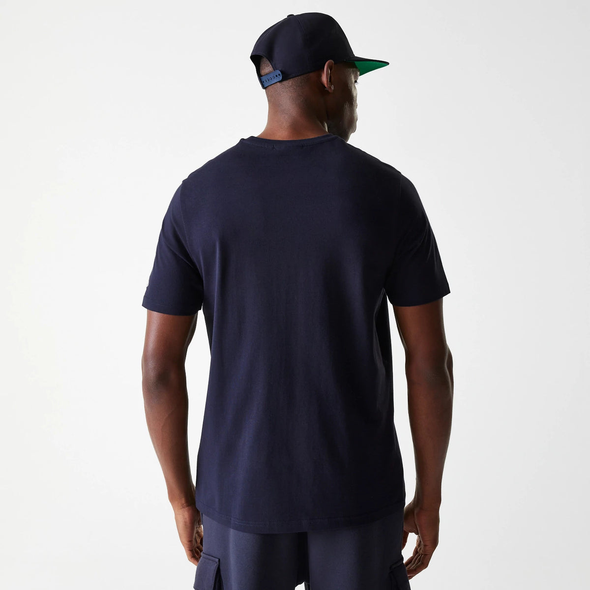 New Era Detroit Tigers MLB Wordmark Navy T-Shirt, on-model rear view showing the plain navy back of the t-shirt, paired with a navy New Era cap featuring a raised logo on the purple back of the cap.