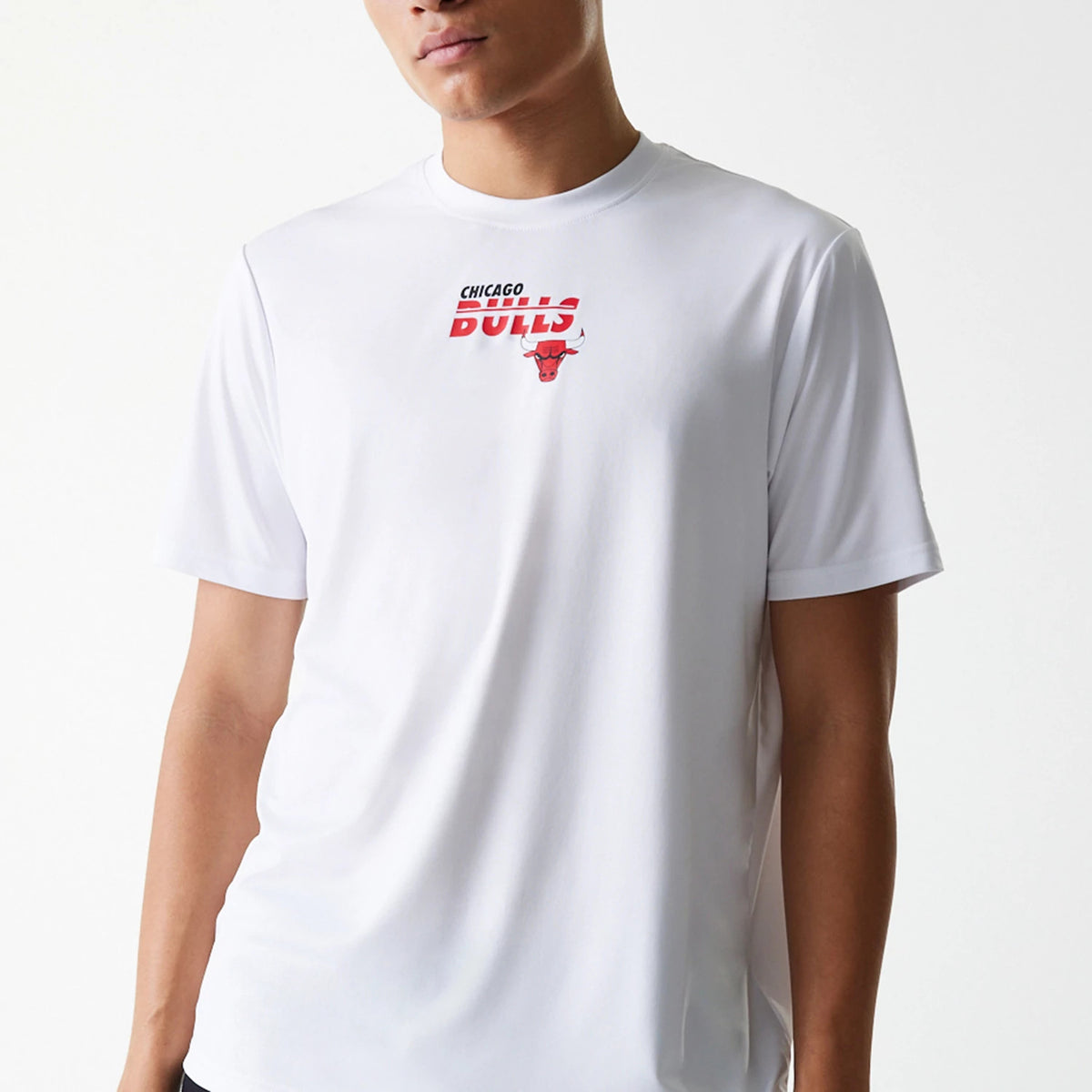 New Era Chicago Bulls NBA Essentials White T-Shirt, front view showing a white shirt with a red and black Chicago Bulls logo printed on the chest, short sleeves, and a round neckline displayed on a model.