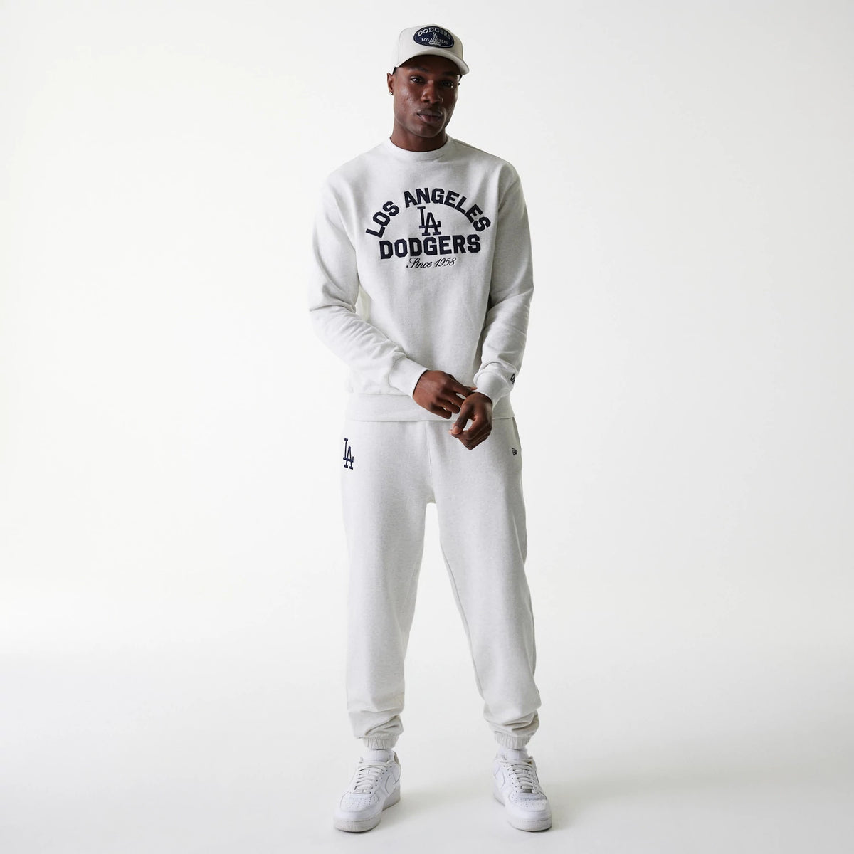 New Era LA Dodgers MLB Heritage Pastel Grey Oversized Crew Neck Sweater, on-model view with matching joggers and cap, featuring a navy Los Angeles Dodgers chest logo and script with ribbed cuffs and hem for a relaxed fit.