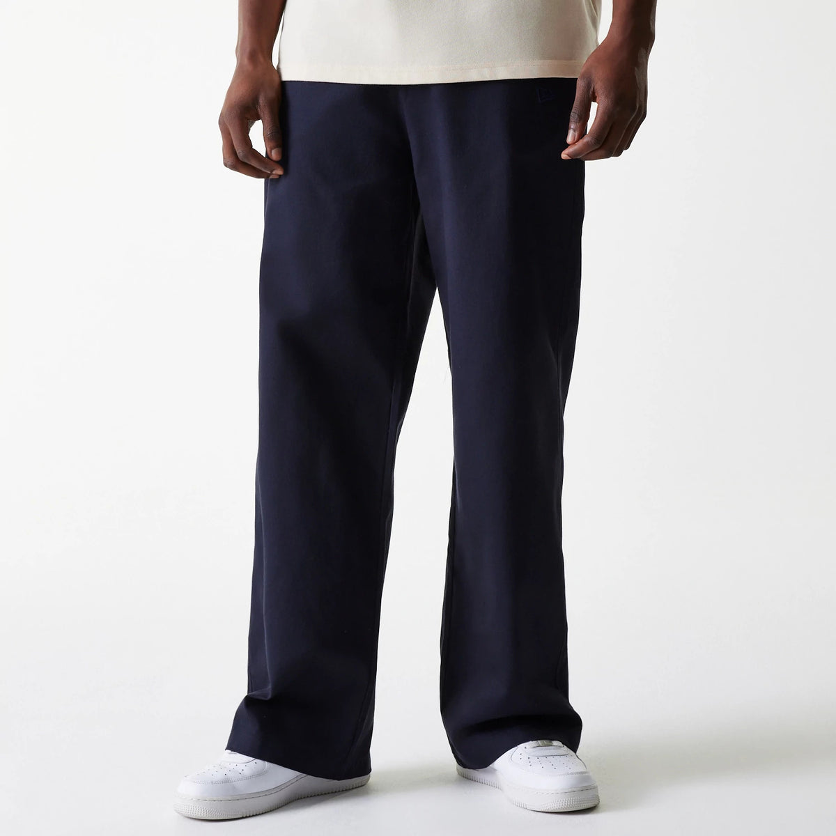 New Era LA Dodgers MLB Navy Chino Trousers, front view on a model wearing a cream shirt, showing the relaxed fit and straight-leg design, with discreet New Era logo embroidery on the left pocket.