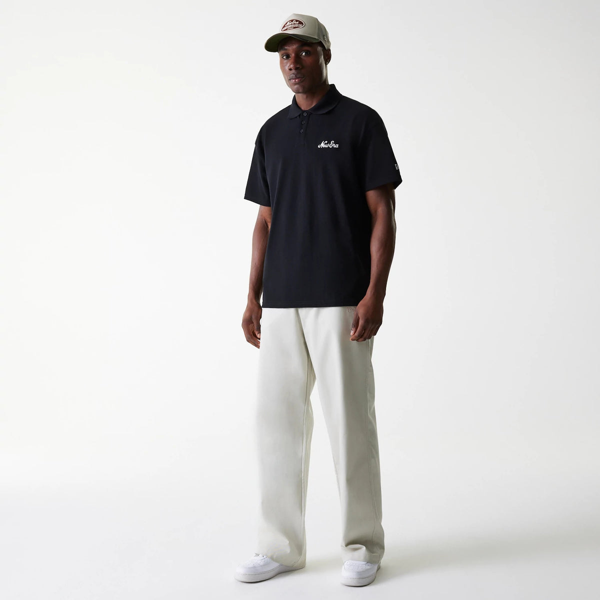 New Era New York Yankees MLB Light Beige Chino Trousers, on-model showing full-length design paired with a black polo shirt and light-coloured trainers, creating a classic casual style.