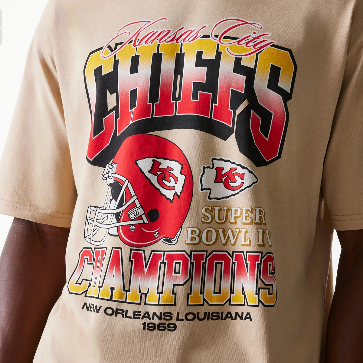 New Era Kansas City Chiefs NFL Washed Super Bowl Beige Oversized T-Shirt, front view showing bold red and yellow CHIEFS text, a red helmet graphic with KC logo, and Super Bowl IV Champions wording with New Orleans Louisiana 1969 below.