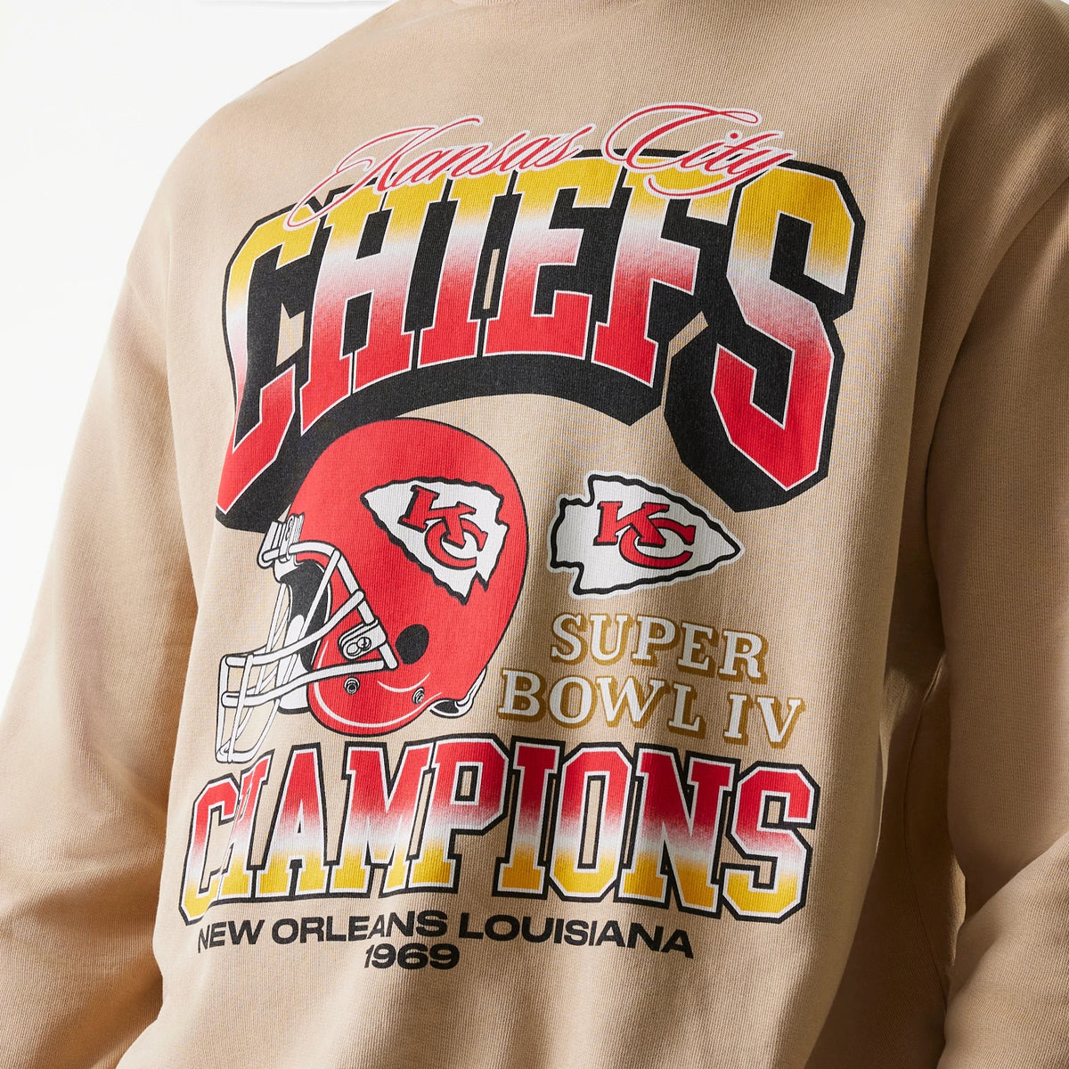 New Era Kansas City Chiefs NFL Washed Super Bowl Beige Oversized Crew Neck Sweater, showing a close-up of the bold red, yellow, and black CHIEFS wordmark, Super Bowl IV and Champions lettering, with a red helmet and logo detailing in the centre back.