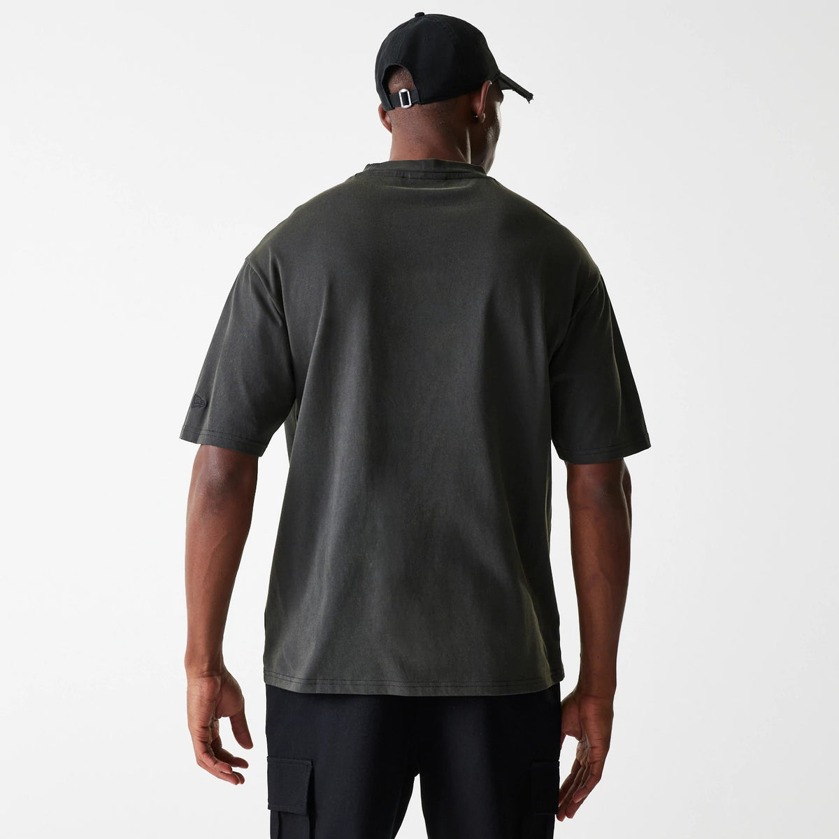 New Era Las Vegas Raiders NFL Washed Super Bowl Grey Oversized T-Shirt, rear view showing the plain grey back with short sleeves, worn by a model, and featuring a black cap with a debossed logo on the side of the sleeve.