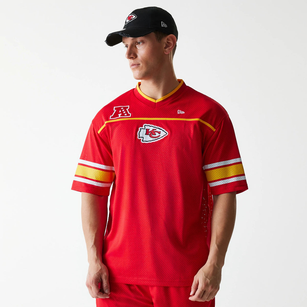 New Era Kansas City Chiefs NFL Mesh Red Jersey, on-model view showing the Chiefs logo on the chest, AFC patch on the right shoulder, and New Era flag logo on the left shoulder, paired with a black team cap.