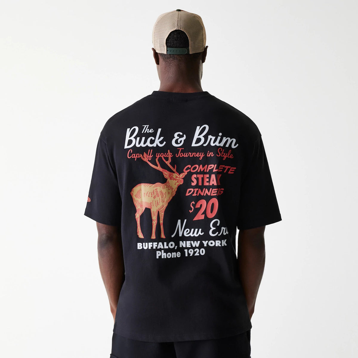 New Era Animal Graphic Black Oversized T-Shirt, on-model rear view showing the large graphic print featuring a deer and restaurant-style text in white and red across the back of the black T-shirt.