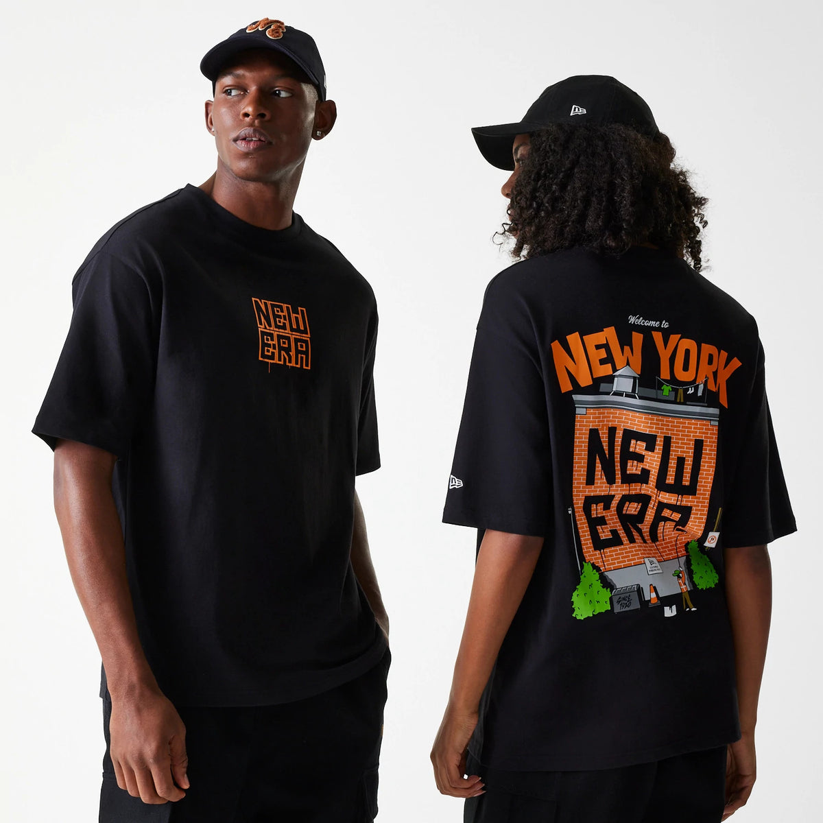 New Era Graffiti Graphic Black Oversized T-Shirt, on-model view showing the front with an orange graffiti-style logo centred on the chest, and the back featuring a large New York themed graffiti graphic spanning the entire back.
