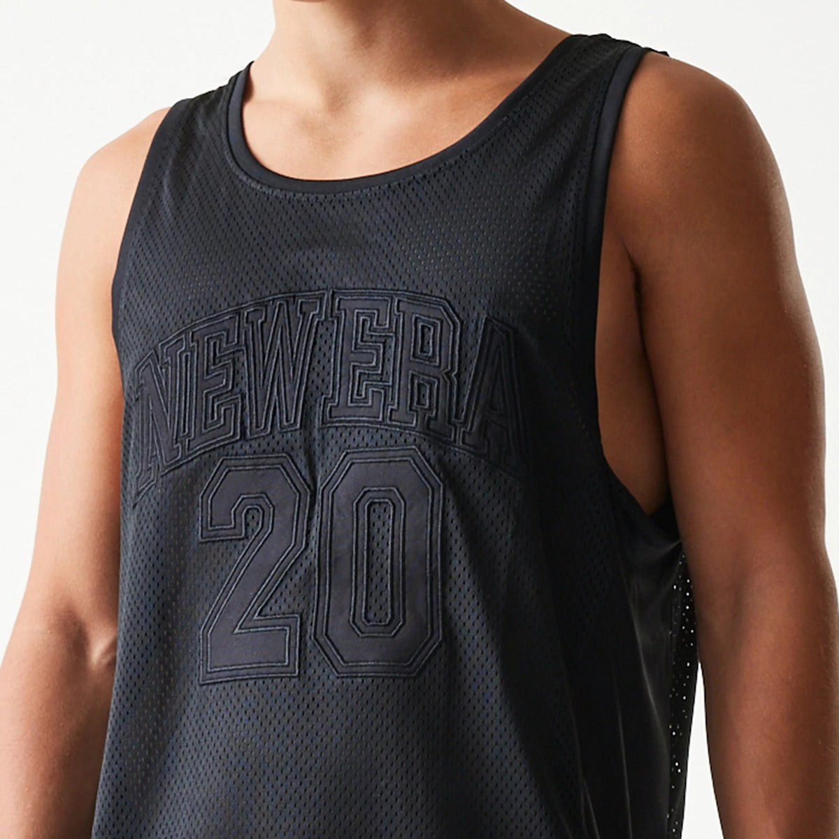 New Era Mesh Black Mesh Vest, front view on a model showing raised black New Era lettering and the number 20 on the chest, with a sleeveless design and a scoop neckline highlighting the mesh texture.