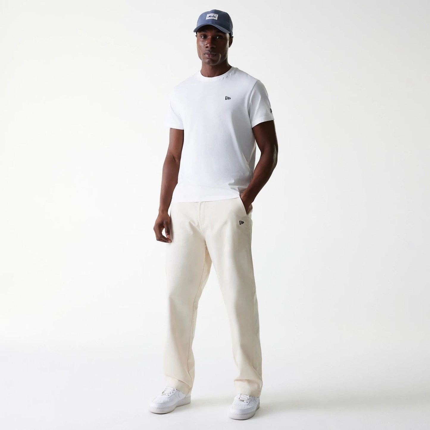 The Male model is wearing New Era Light Beige Chino Trousers 8