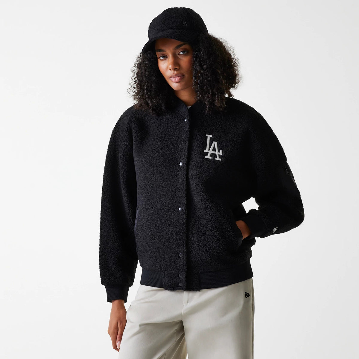 New Era LA Dodgers Womens MLB Black Oversized Sherpa Bomber Jacket, on-model view showing a black textured bomber jacket with a grey LA logo on the chest, snap button closure, ribbed cuffs, and a black New Era logo on the sleeve.