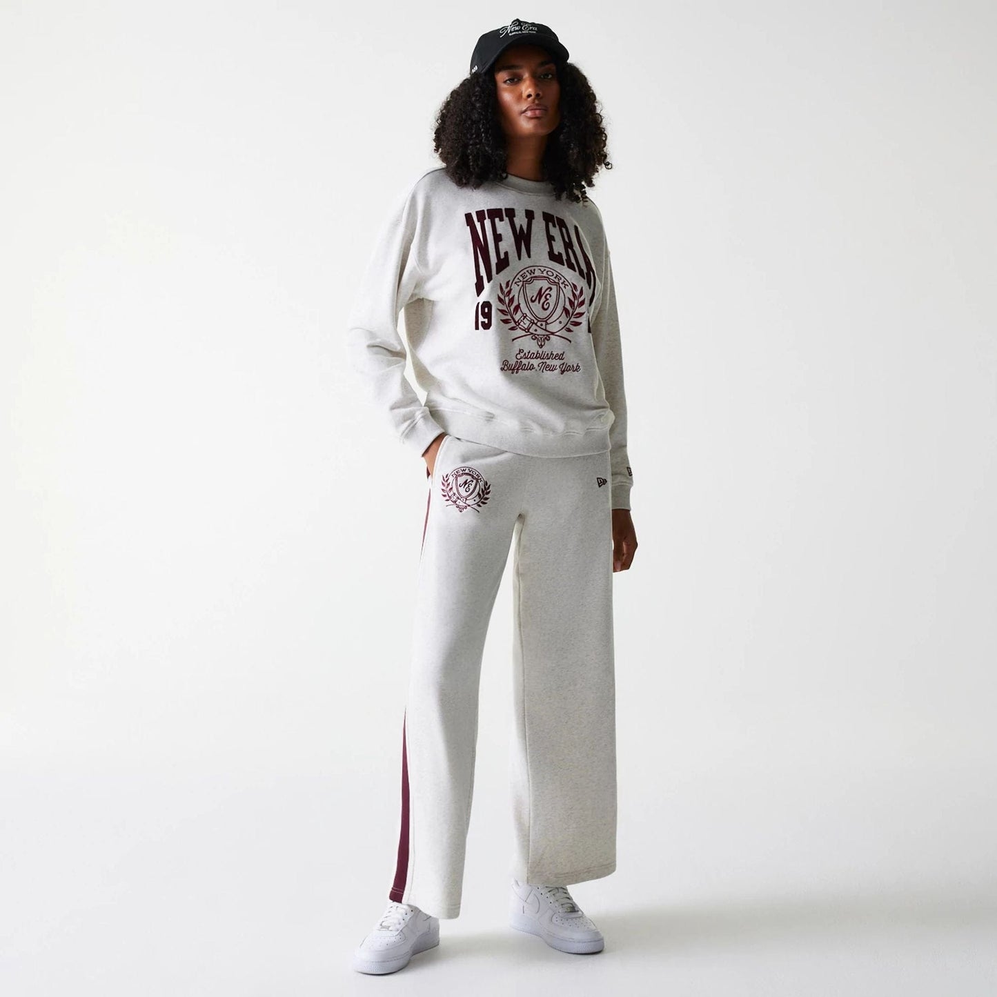 The Female model is wearing Womens New Era Crest Graphic Pastel Grey Crew Neck Sweater 8