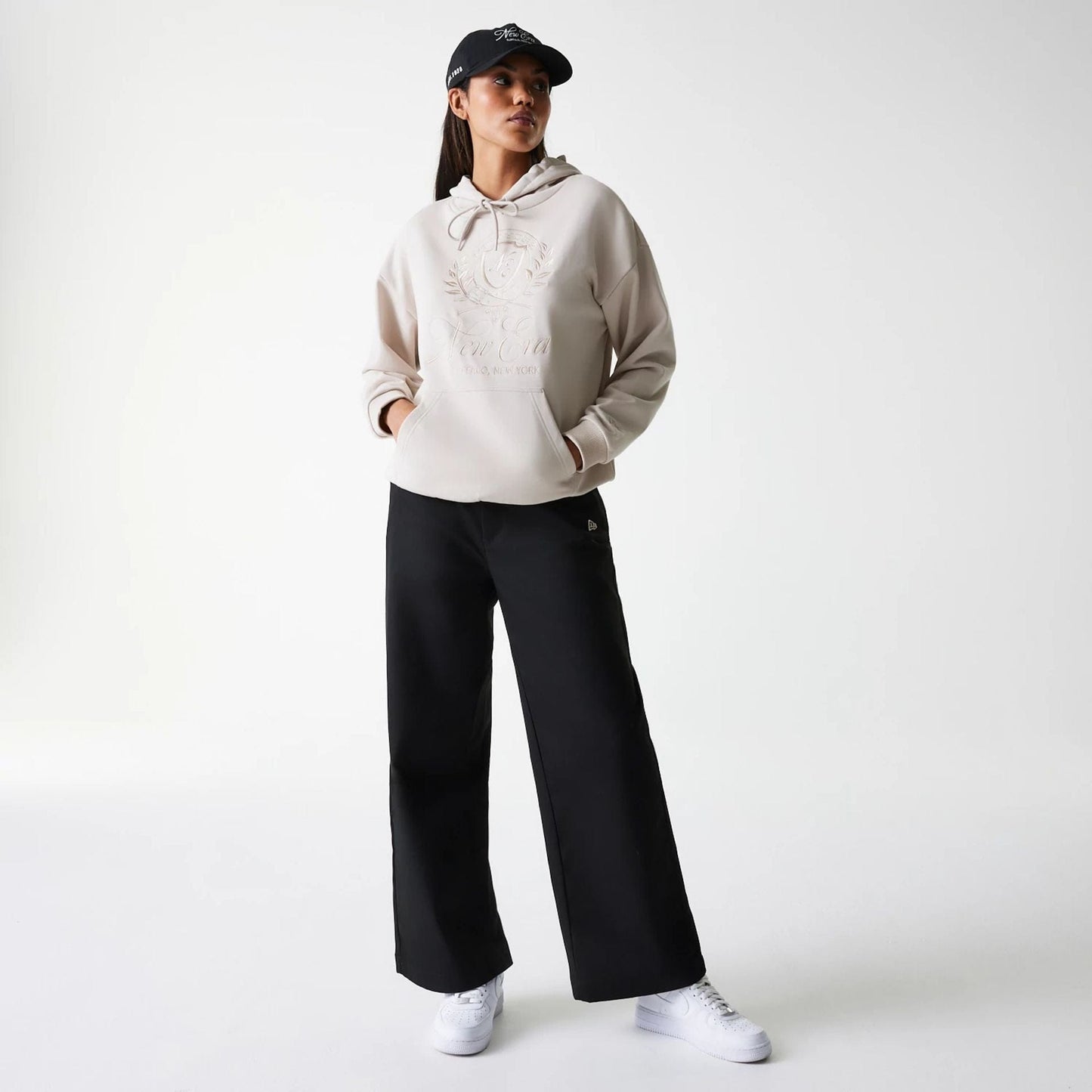 The Female model is wearing Womens New Era Crest Light Beige Pullover Hoodie 8