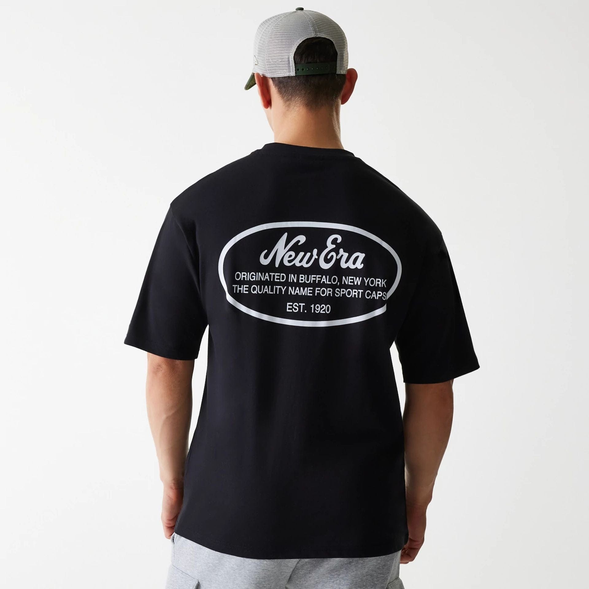 The Male model is wearing New Era Trucker Patch Black Oversized T-Shirt 2