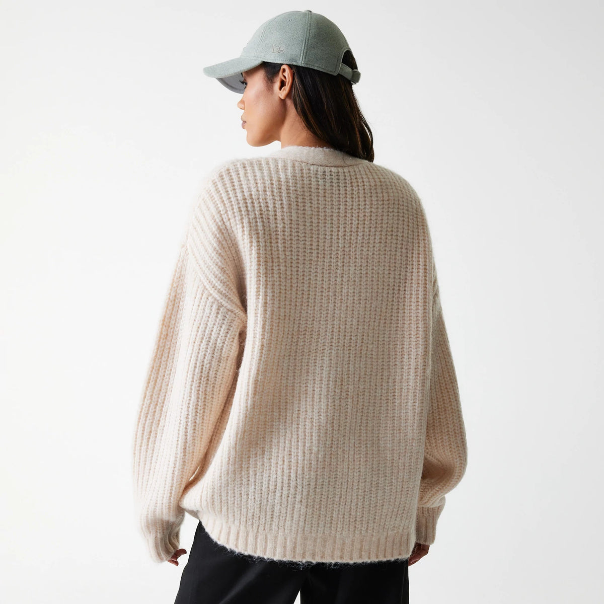 New Era LA Dodgers Womens MLB Knit Light Beige Cardigan, rear view on a model wearing a pale cap, showing full-length ribbed knit design with a relaxed fit, dropped shoulders, and ribbed cuffs for a cosy and casual look.