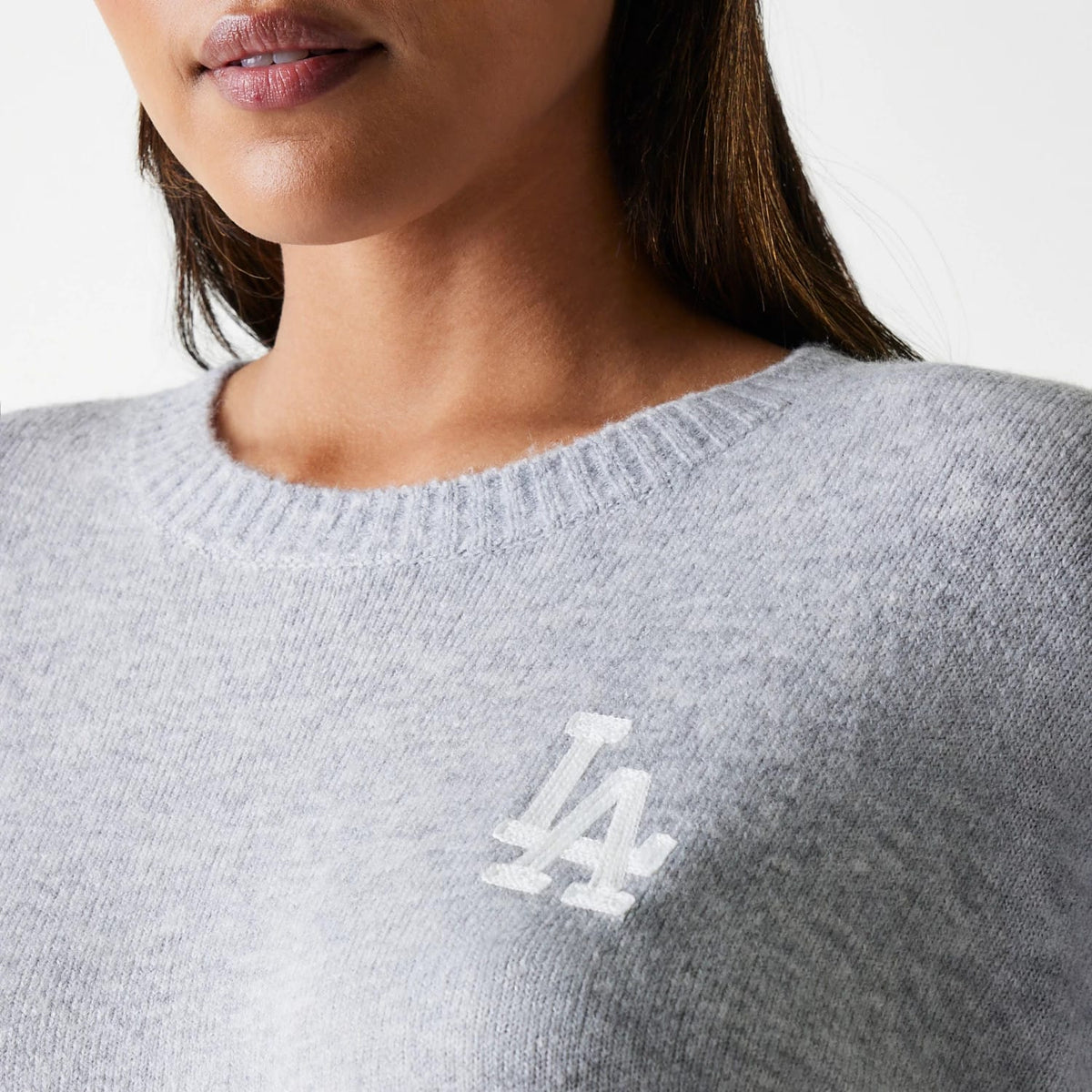 New Era LA Dodgers Womens MLB Knit Grey Crew Neck Sweater, on a model with the white embroidered LA logo on the left chest and a ribbed neckline, highlighting the soft knit fabric texture.