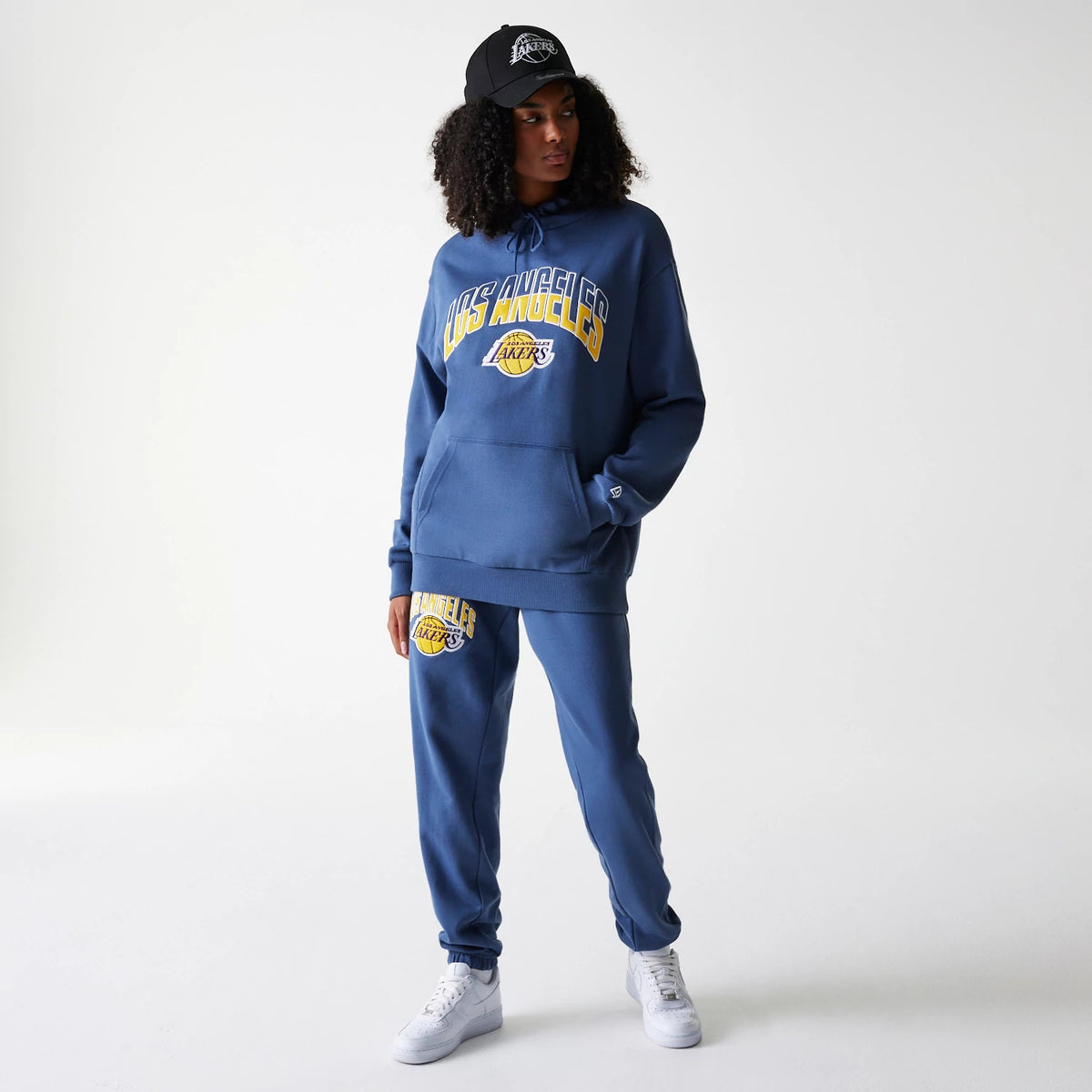 The Male model is wearing LA Lakers NBA Arch Graphic Dark Blue Joggers 4
