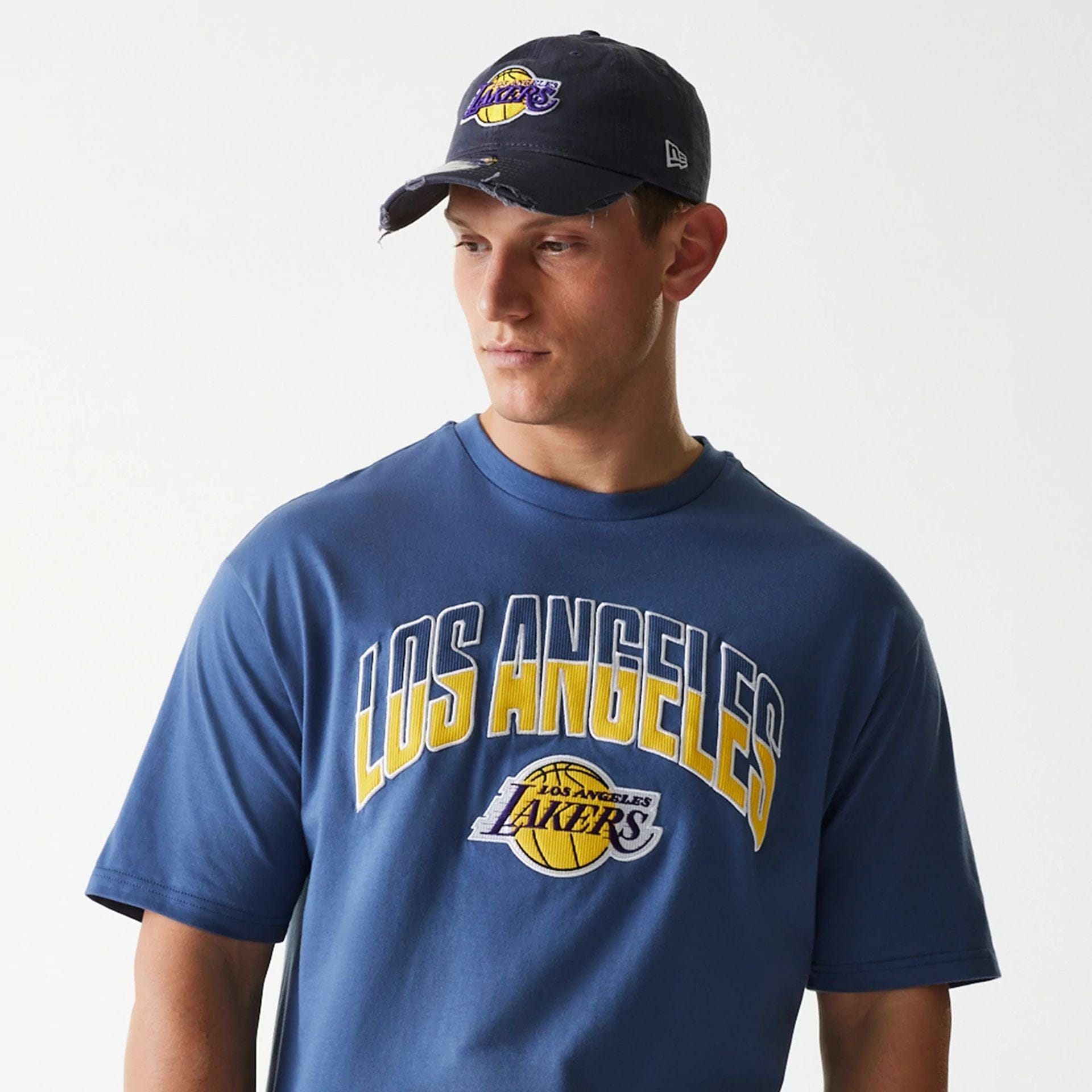 The Male model is wearing LA Lakers NBA Arch Graphic Dark Blue Oversized T-Shirt 1