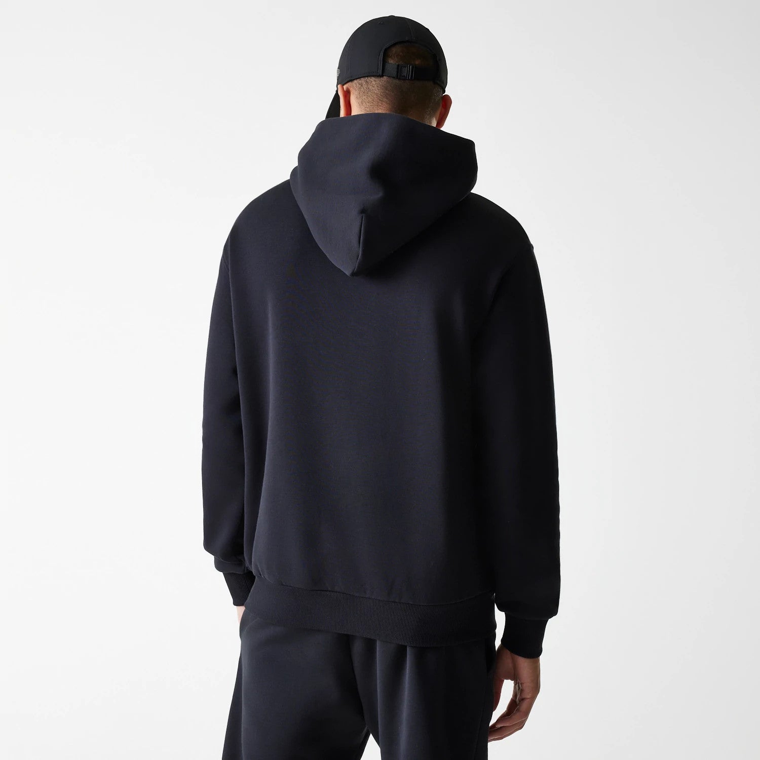 The Male model is wearing New Era Tech Black Oversized Pullover Hoodie 2
