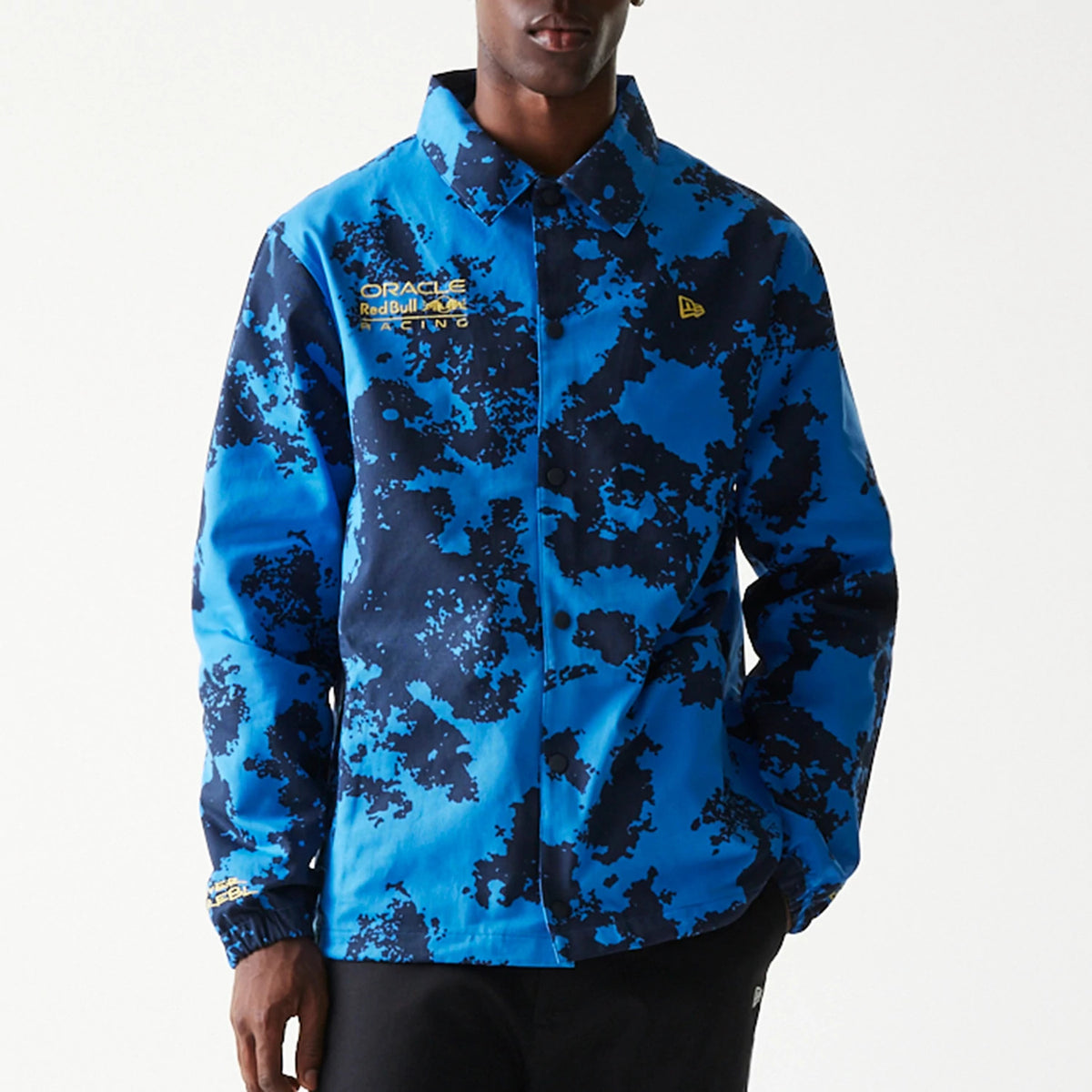 New Era Red Bull Racing Blue Oversized Coach Jacket, front view showing a blue and black abstract pattern, the Oracle Red Bull Racing logo on the left chest, and a raised New Era logo on the right chest.