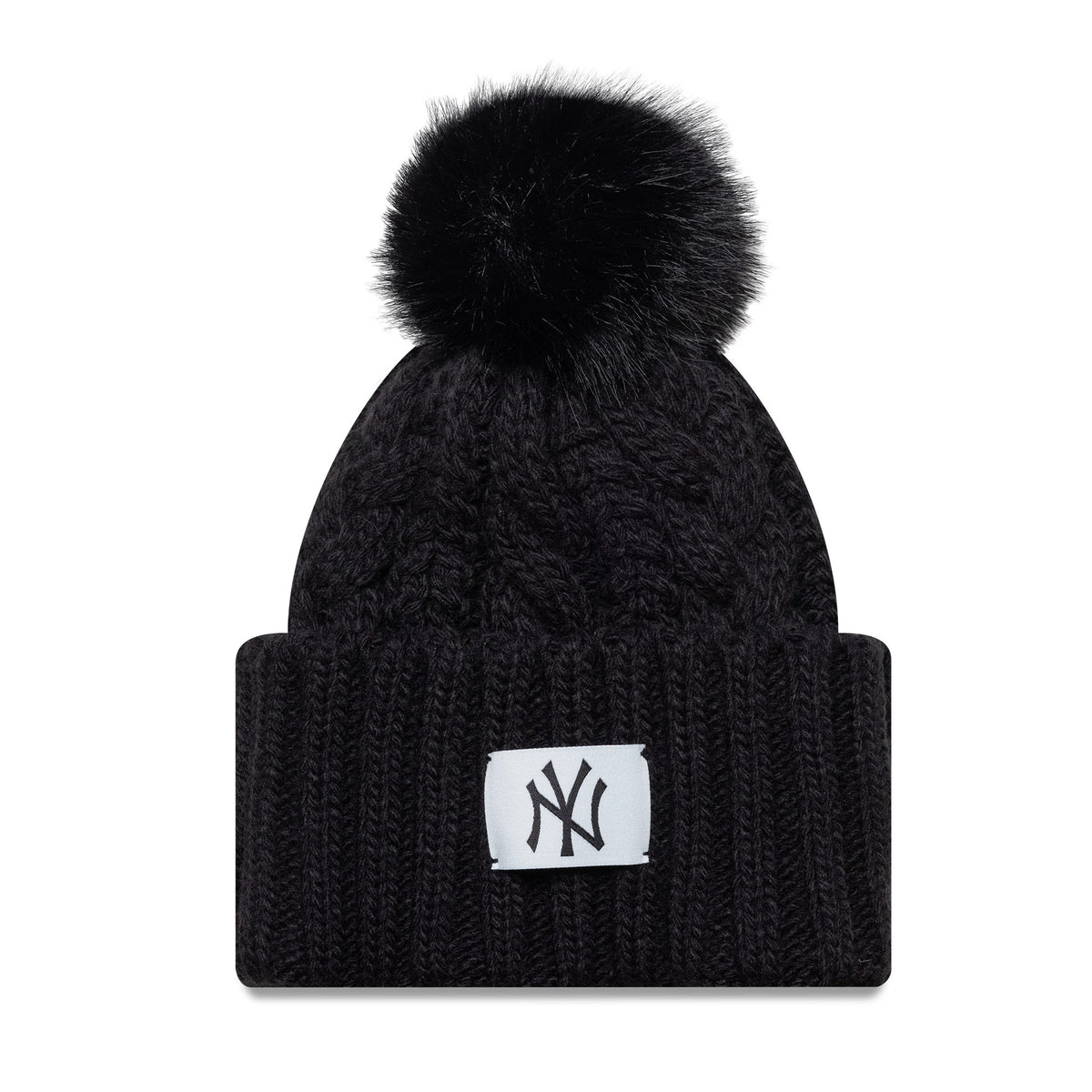 New Era New York Yankees Youth MLB Black Cable Knit Beanie Hat, front view showing the raised embroidered NY logo patch on the folded cuff, with a cable knit pattern on the crown and a fluffy black pom-pom on top.