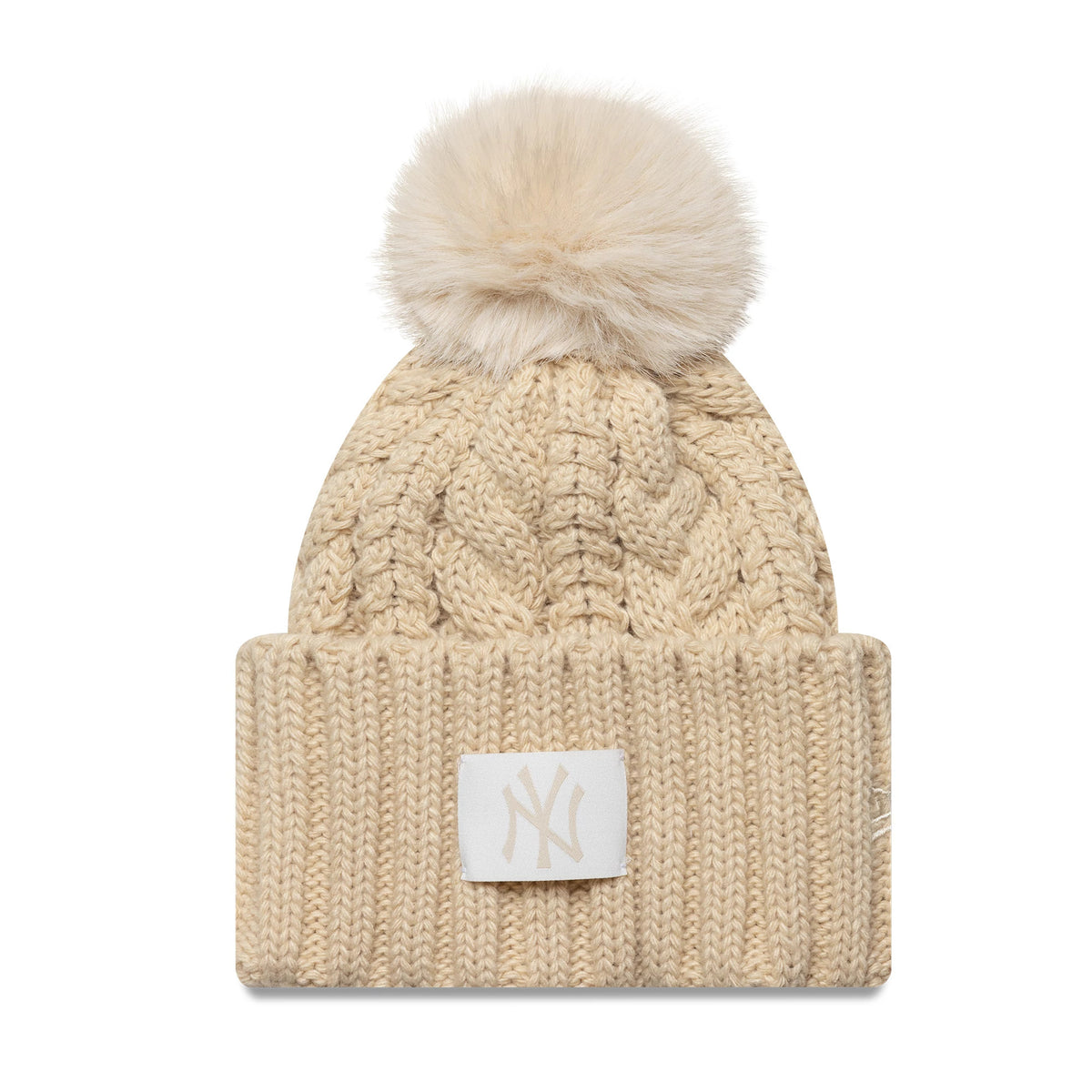 New Era New York Yankees MLB Light Beige Cable Knit Beanie Hat, front view showing the cable knit pattern, a soft faux fur pompom on top, and an embroidered NY logo patch on the folded cuff.