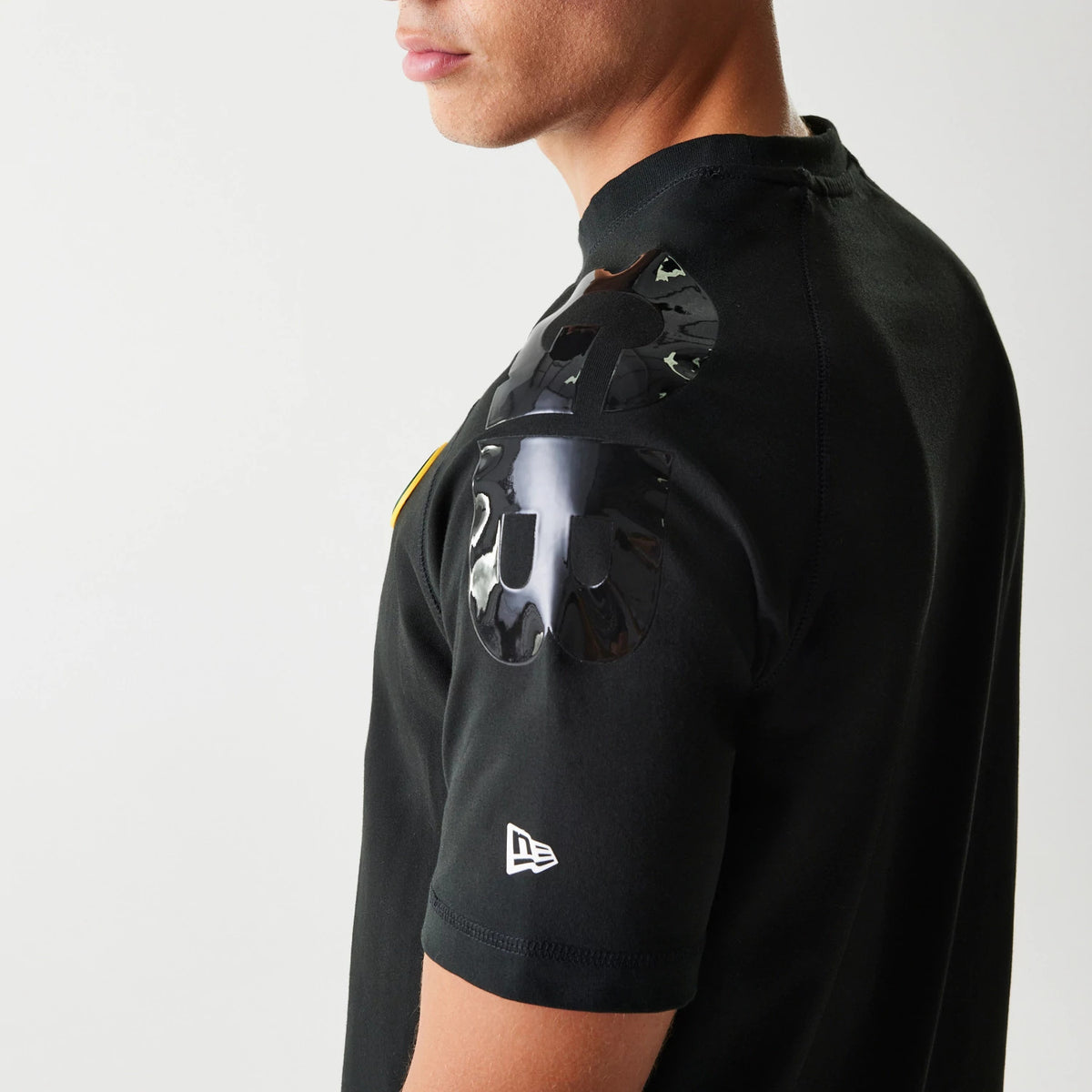 New Era Green Bay Packers NFL 3RD Down Black T-Shirt, side view showing a glossy raised graphic on the shoulder and a small white embroidered New Era logo near the sleeve hem on a model.