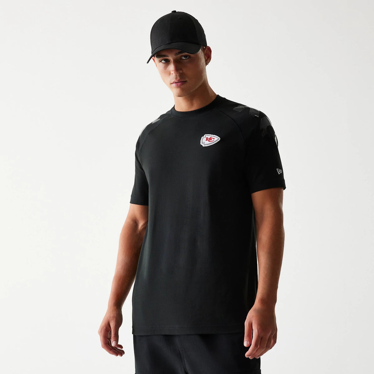 New Era Kansas City Chiefs NFL 3RD Down Black T-Shirt, front view showcasing an embroidered team logo on the chest and a New Era logo on the left sleeve, styled on a model wearing a black cap.