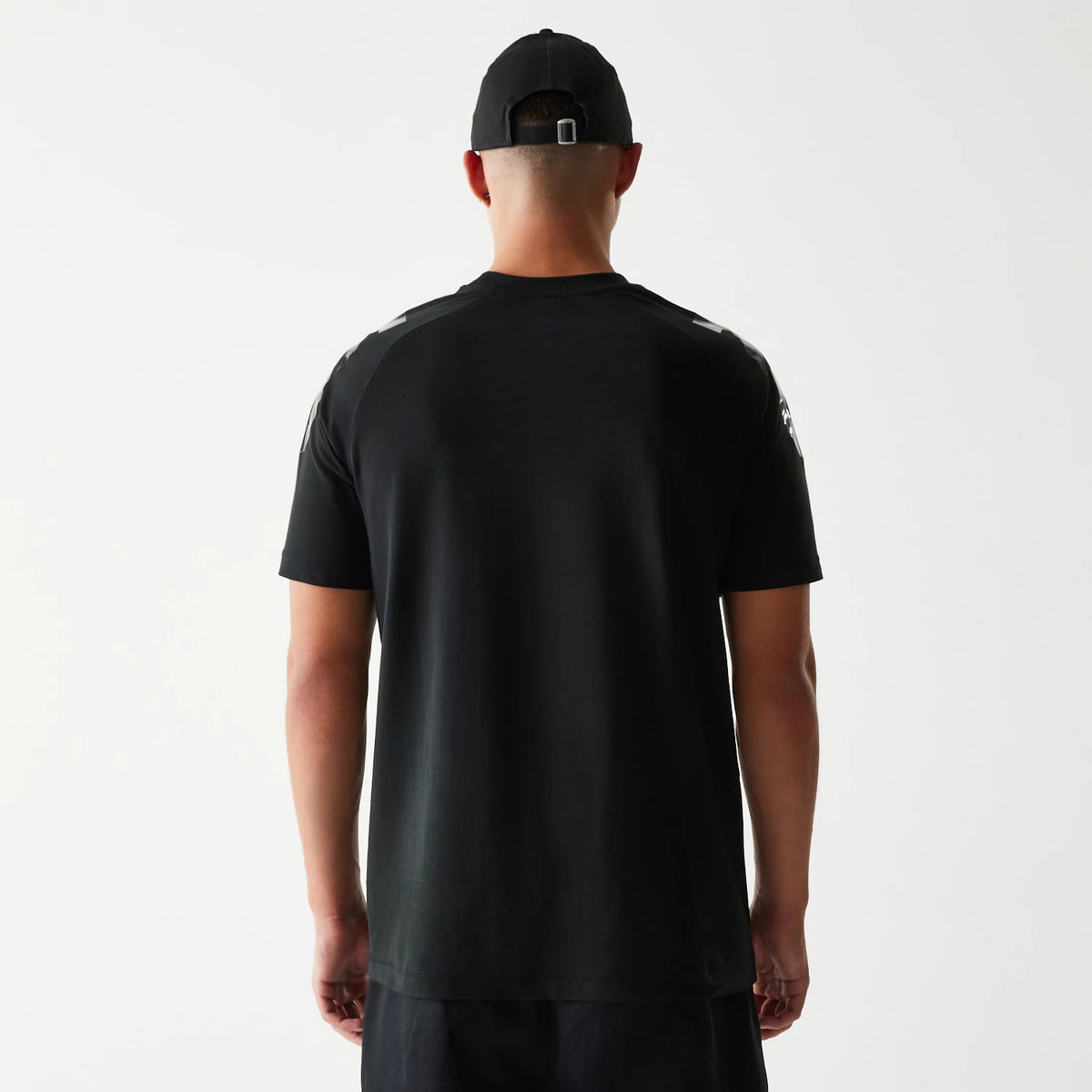 New Era Kansas City Chiefs NFL 3RD Down Black T-Shirt, back view on-model showing a plain black back with an embroidered New Era logo on the right shoulder and matching black cap styling for a coordinated look.