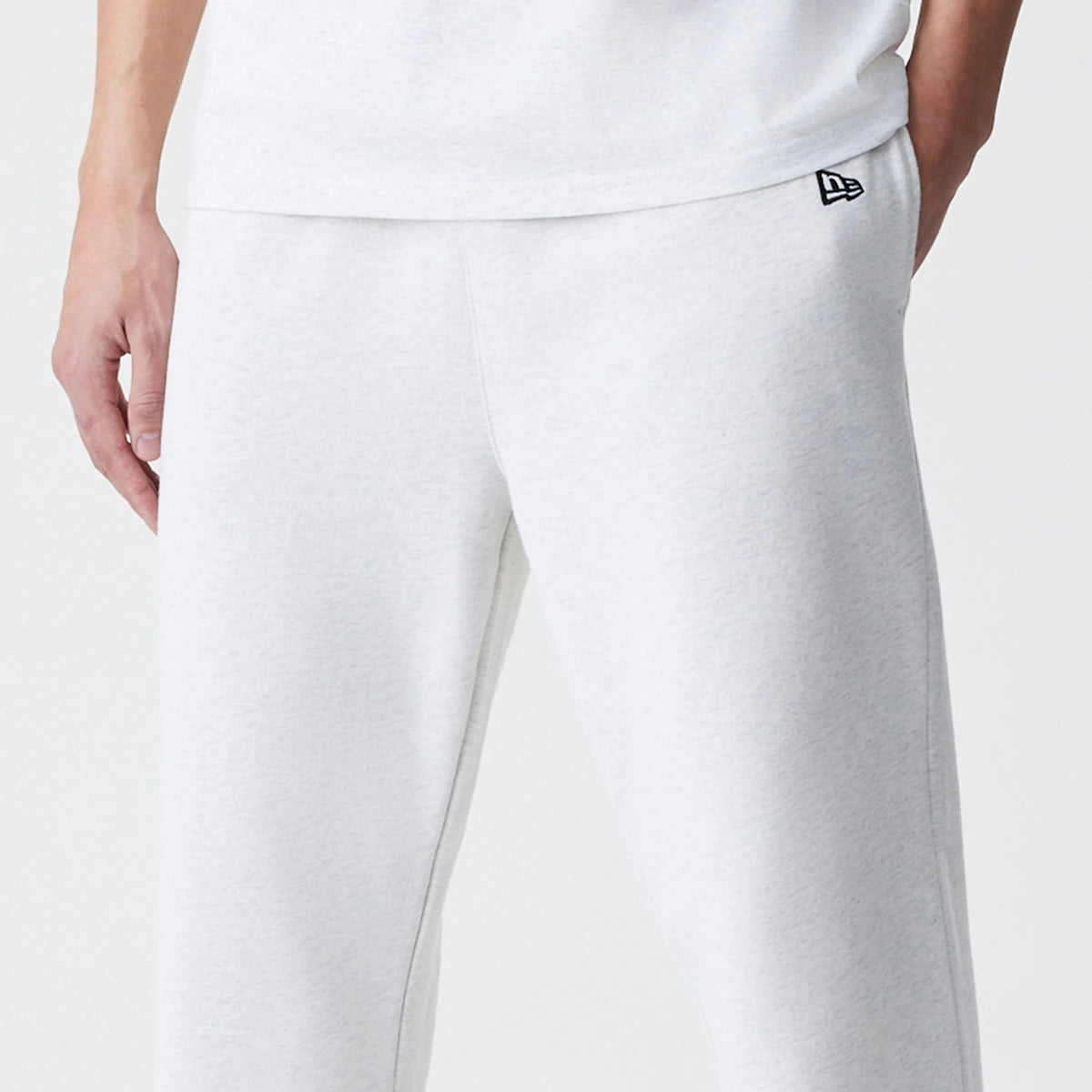 New Era Premium Essential Pastel Grey Joggers, front view showing the small black embroidered New Era flag logo on the left hip with sleek, minimalist styling and a comfortable fit.
