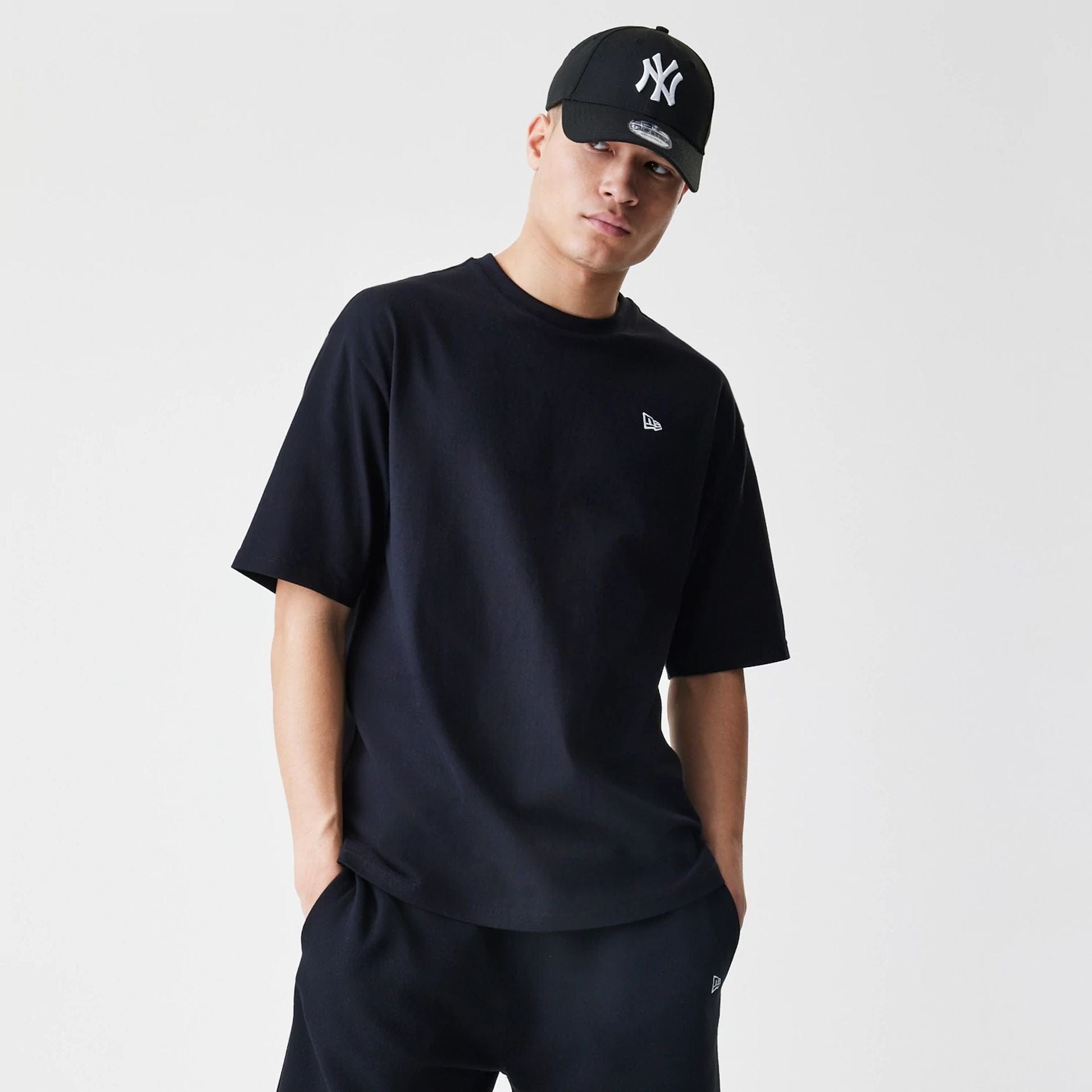 The Male model is wearing New Era Premium Essential Black Oversized T-Shirt 1