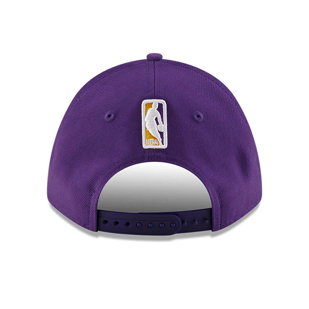 LA Lakers NBA Team Purple New Era 9FORTY M-Crown Adjustable Cap, rear view showing the embroidered NBA logo at the centre of the back panels above the adjustable strap, set on a deep purple structured crown.