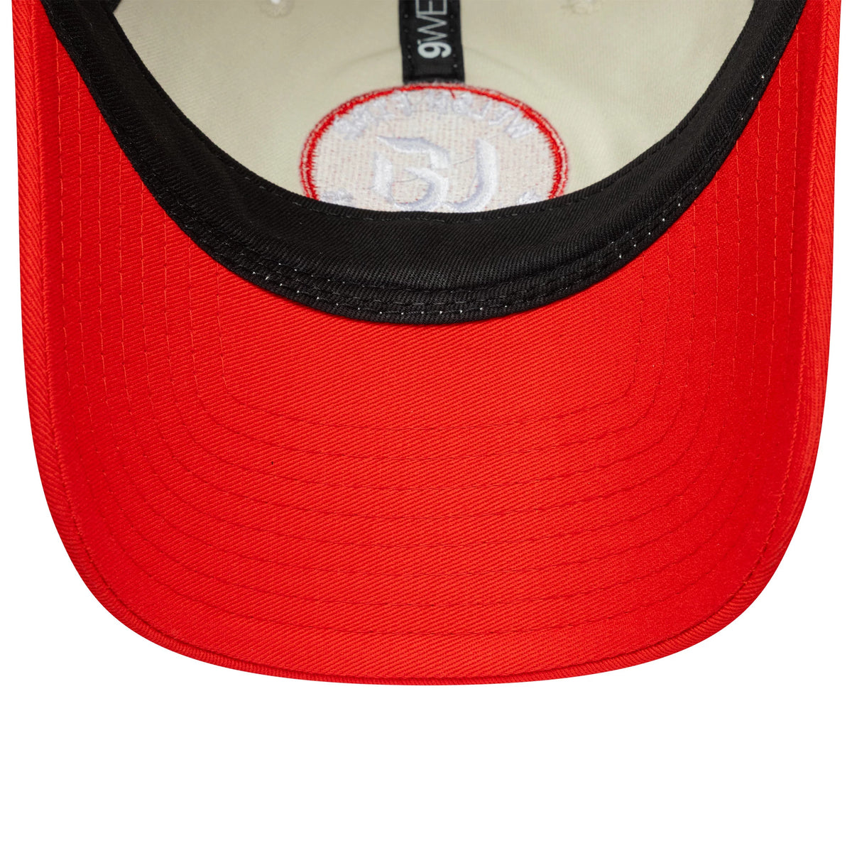 Welsh Fire Tan Cymreig The Hundred 2025 Contrast Light Beige New Era 9TWENTY Adjustable Cap, inside view showing the black sweatband with New Era branding, a white undervisor and a red and white circular patch on the panel.