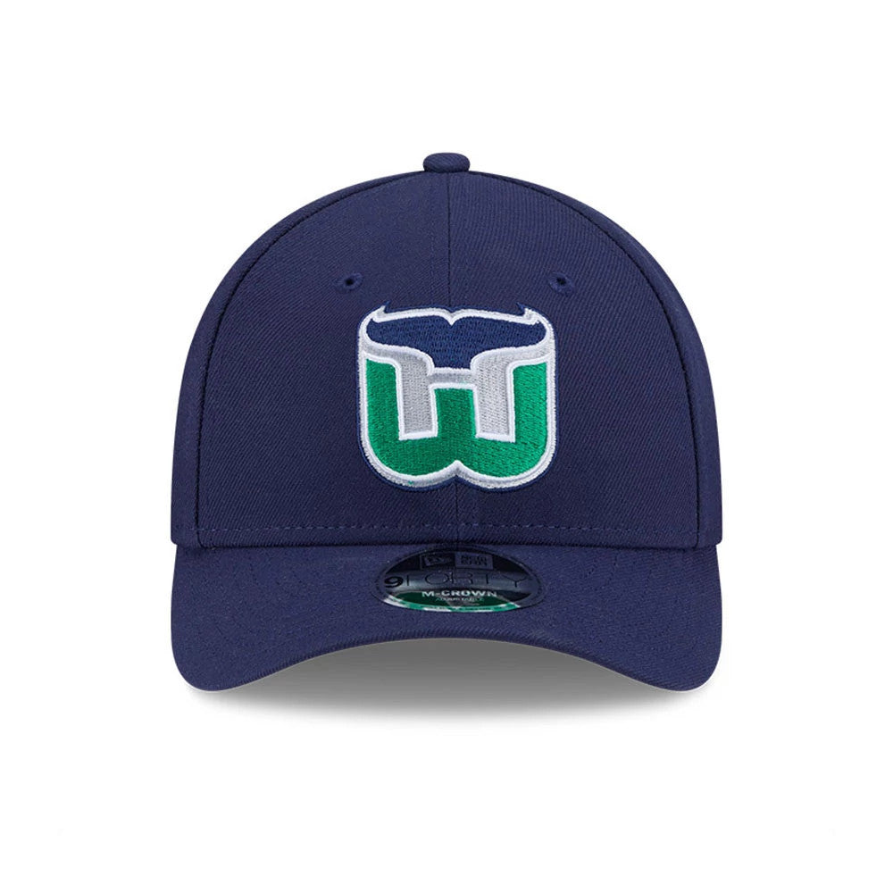 Hartford Whalers NHL Team Navy New Era 9FORTY M-Crown Adjustable Cap, front view showing the raised embroidered white and green team logo on the front panel with a curved navy visor and 9FORTY size sticker on top.
