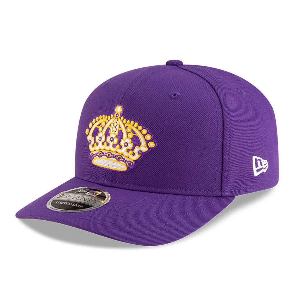 LA Kings NHL Team Purple New Era 9SEVENTY Stretch Snap Adjustable Cap, three-quarter view showing a yellow embroidered crown logo on the front panel, purple curved visor, and silver 9SEVENTY size sticker.