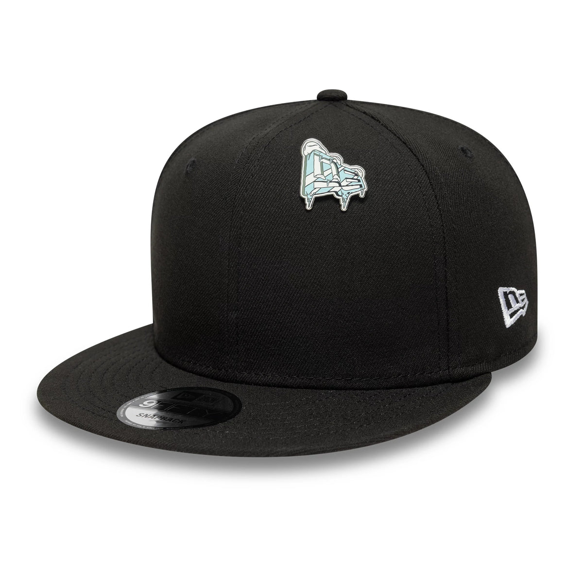 New Era Iced Flag Blue Pin Badge, three-quarter view showing a black cap with a blue pin badge on the front of the crown, an embroidered New Era logo on the side, and a flat visor with a sticker on top.