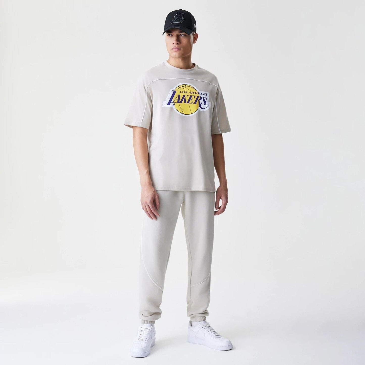 The Male model is wearing LA Lakers NBA Piping Light Beige Oversized T-Shirt 8