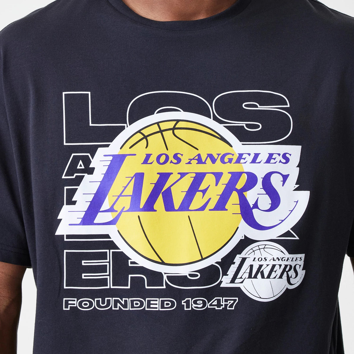 New Era LA Lakers NBA Outline Graphic Navy Oversized T-Shirt, front view showing a large yellow basketball graphic with purple Los Angeles Lakers lettering across the chest, set against white LA lettering and Founded 1947 text below.
