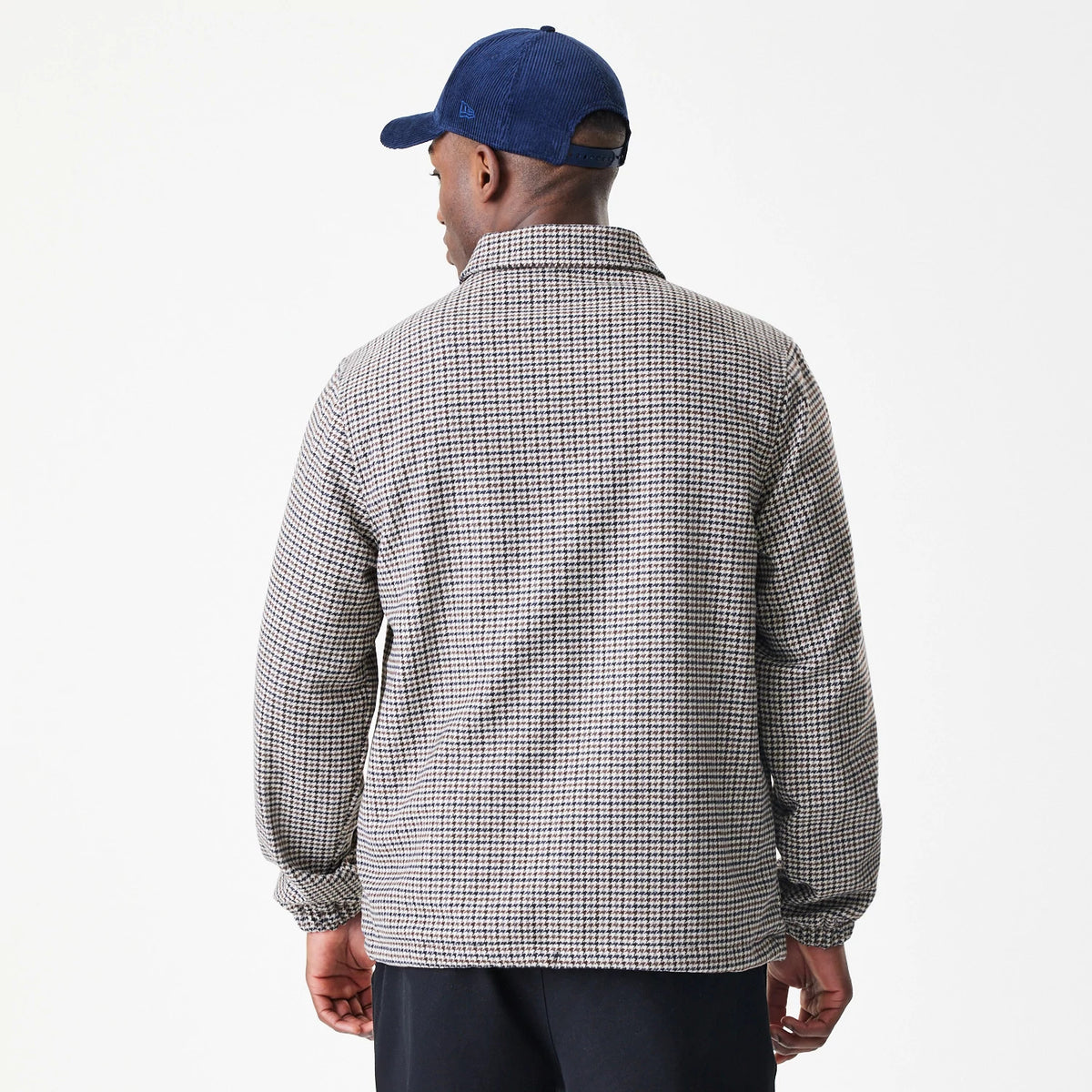 New Era New York Yankees MLB Check Brown Jacket, back view on-model showcasing a small check pattern throughout with a classic collar and long sleeves, styled with a matching dark blue cap with an embroidered New Era logo on the side.