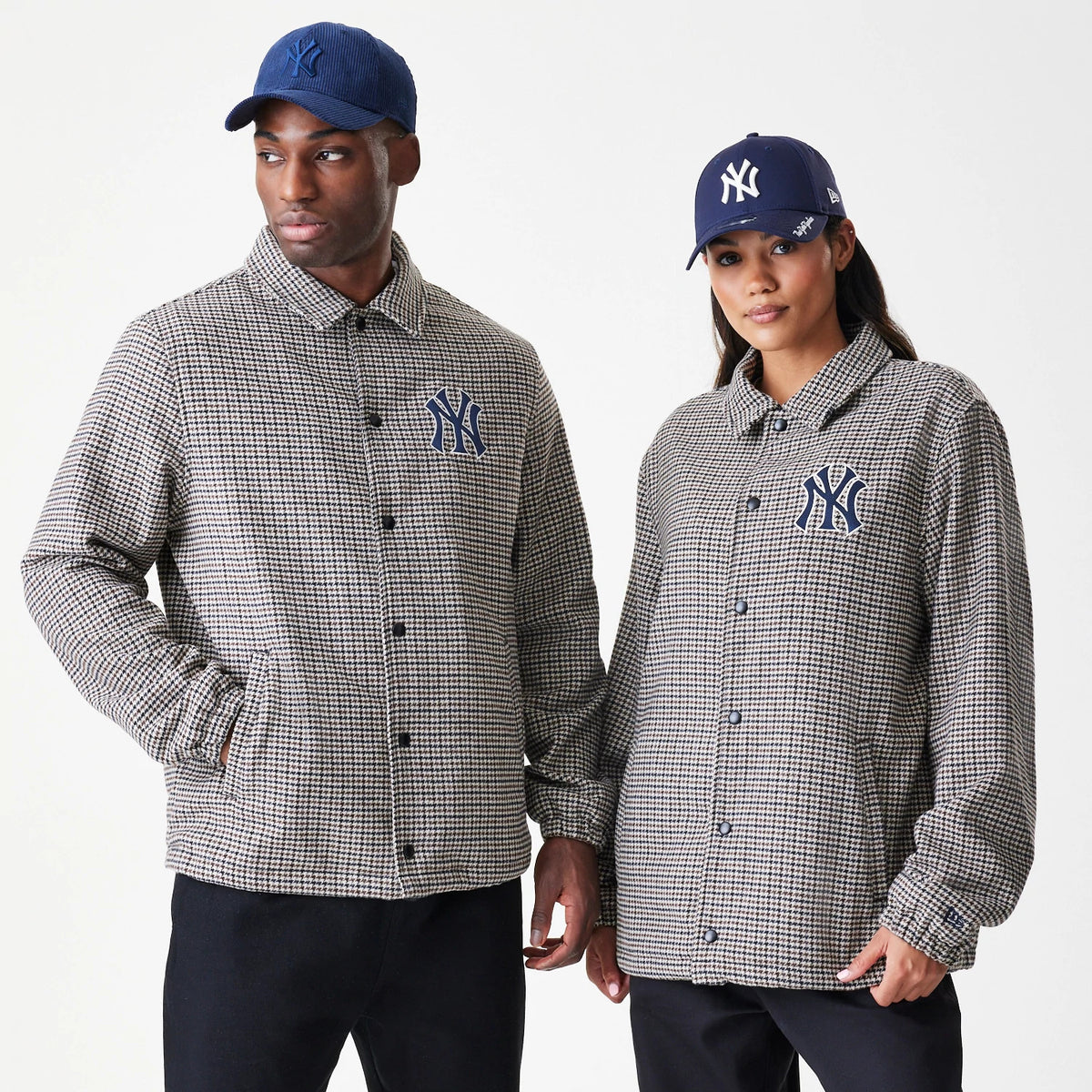 New Era New York Yankees MLB Check Brown Jacket, front view on-model displaying the check pattern with an embroidered Yankees logo on the left chest, featuring a button closure and long sleeves, paired with a navy cap with an embroidered logo.