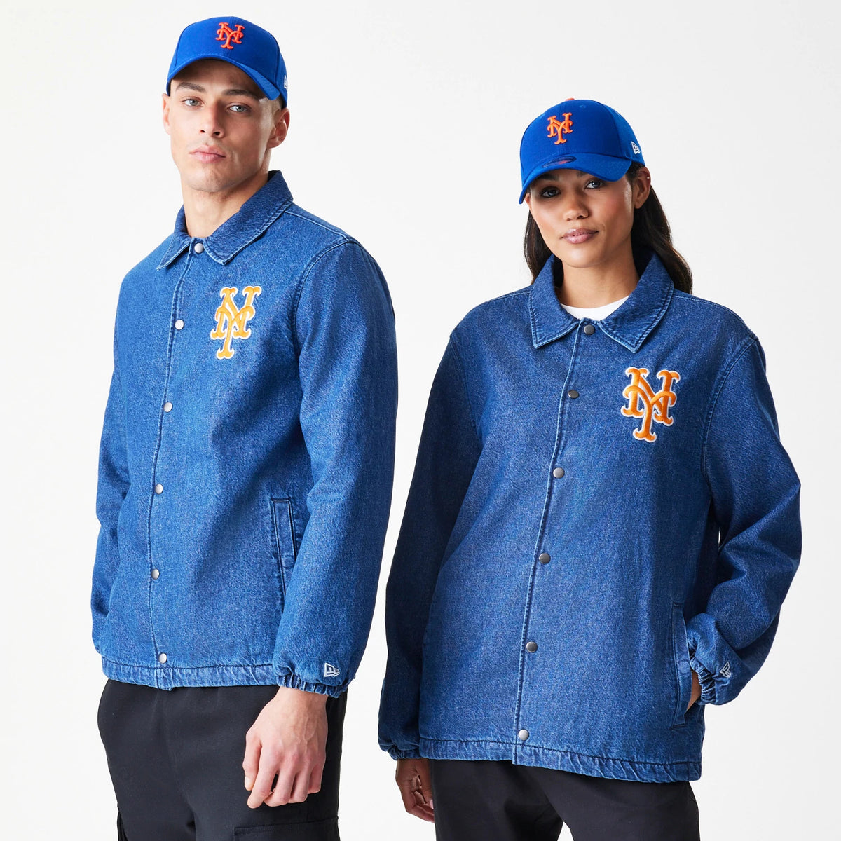 New Era New York Mets MLB Denim Dark Blue Coaches Jacket, front view on models wearing blue caps, displaying the orange and white embroidered NY Mets logo on the left chest and the embroidered New Era flag on the left sleeve cuff.