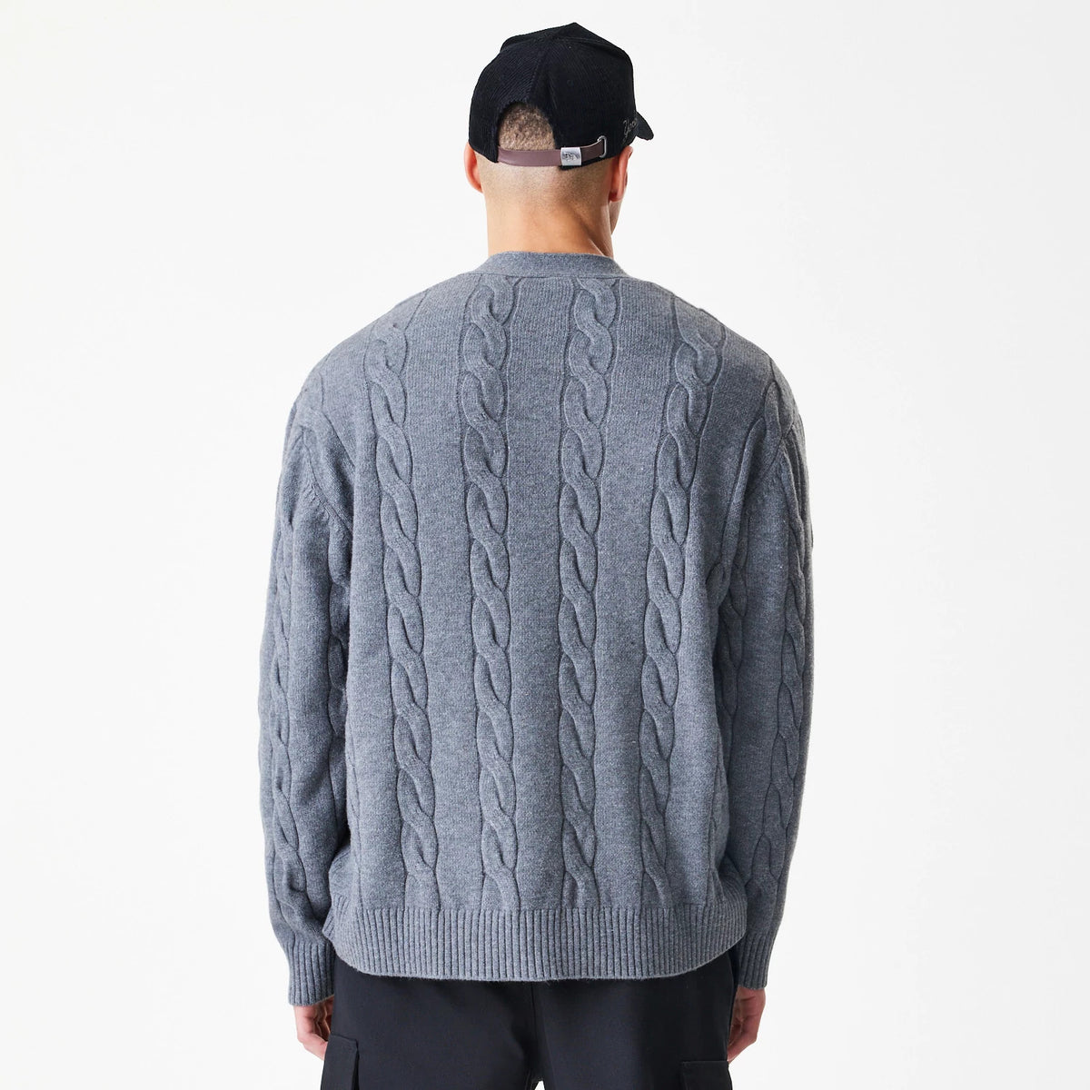 New Era New York Yankees MLB Cable Knit Dark Grey Cardigan, back view on a model showing the intricate cable knit pattern running vertically down the dark grey fabric, combined with a ribbed hemline and cuffs for a classic look.