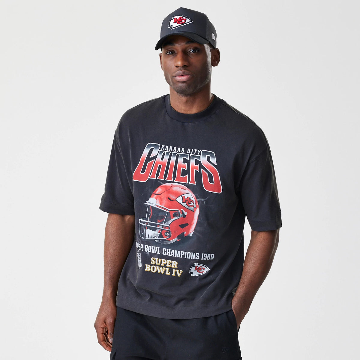 New Era Kansas City Chiefs NFL Washed Boxy Black Oversized T-Shirt, front view on-model displaying a Chief's helmet graphic, red and white team lettering across the chest and Super Bowl IV details beneath the image.