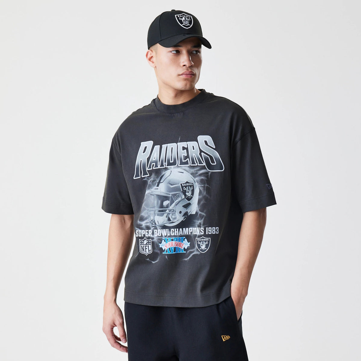 New Era Las Vegas Raiders NFL Washed Boxy Dark Grey Oversized T-Shirt, front view on-model showing the Raiders graphic with a football helmet and Super Bowl Champions 1983 text, a small embroidered New Era logo on the left sleeve.