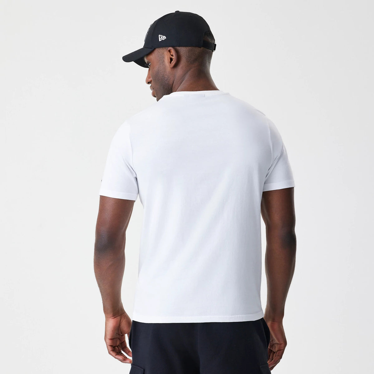 New Era LA Lakers NBA Script White T-Shirt, back view on a model with a black cap, showing the plain white back of the T-shirt and short sleeves, with no graphics or logos on this side.