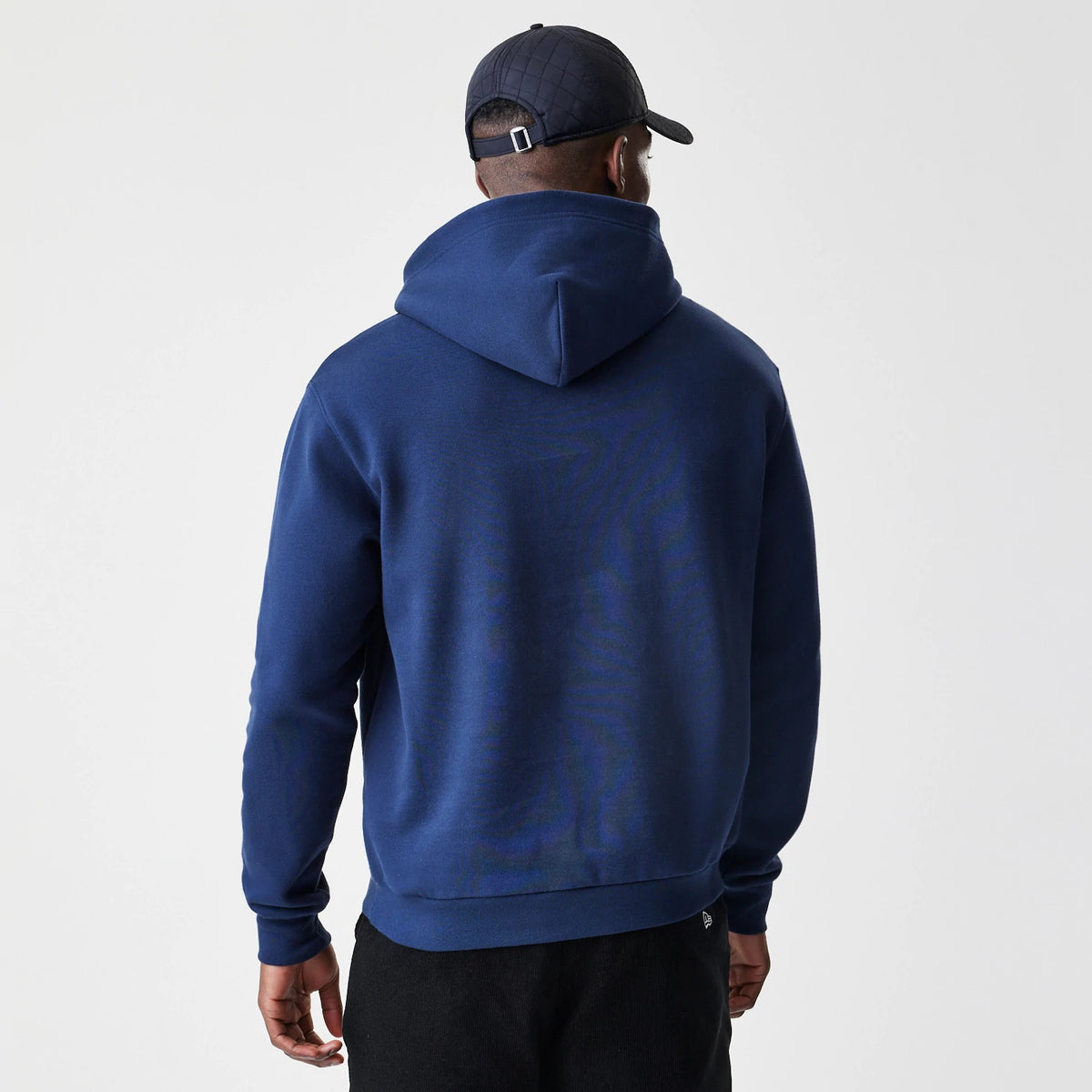 New Era New York Yankees MLB Script Navy Oversized Pullover Hoodie, back view on a model showing the simple navy design with a large hood and a small embroidered New Era logo near the hem.