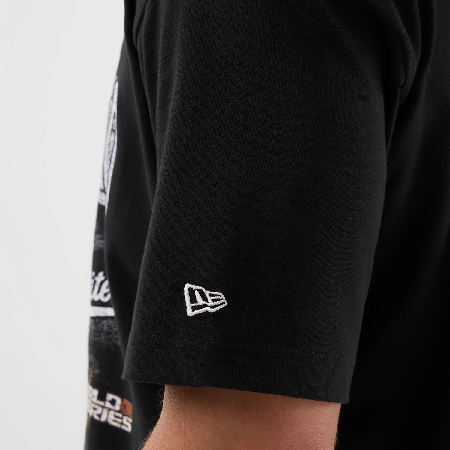 New Era Chicago White Sox MLB Sport Classic Black T-Shirt, side view showing the embroidered white New Era logo on the sleeve, view of the graphic design on the torso, worn by a model.