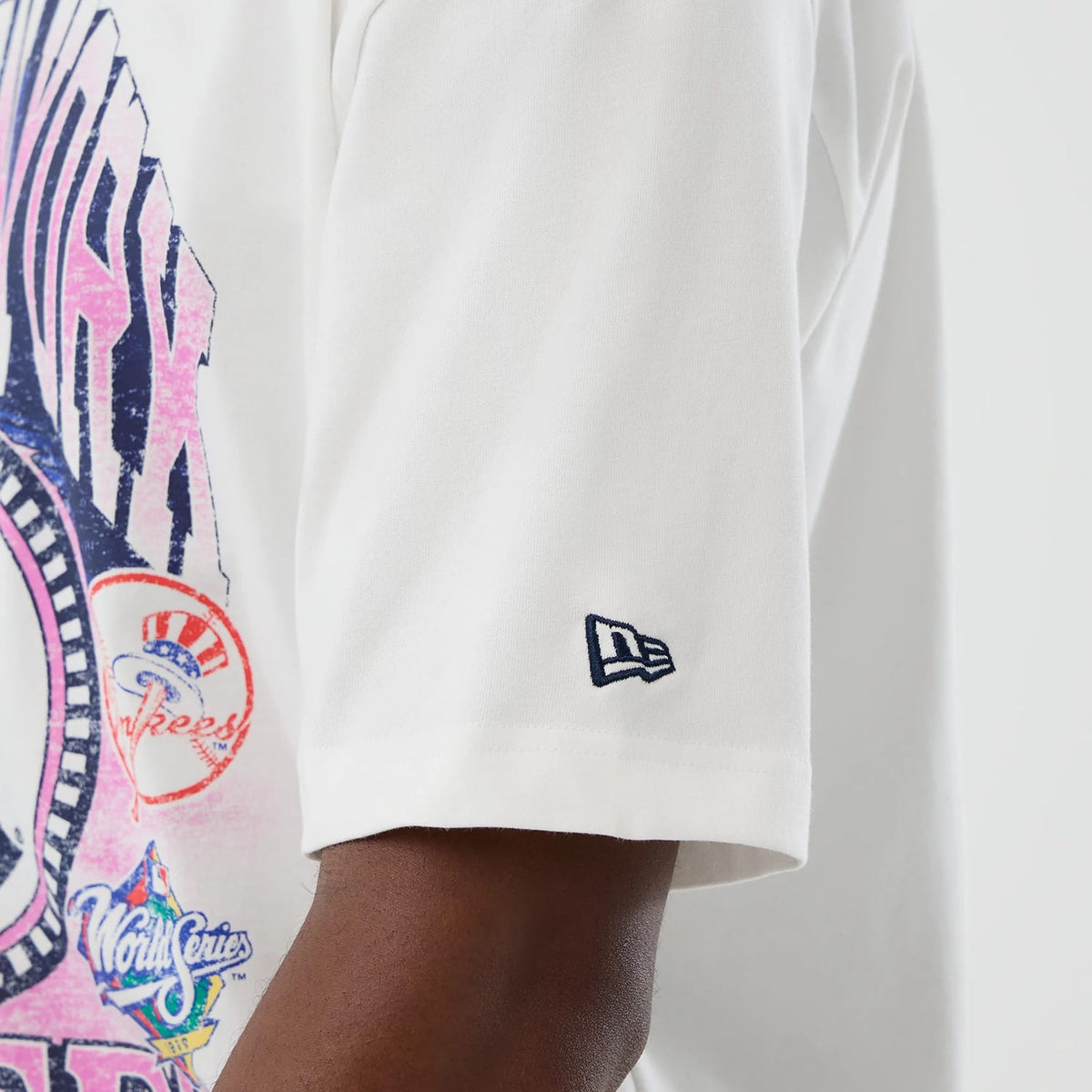 New Era New York Yankees Cooperstown MLB Sport Classic White T-Shirt, side view showing a colourful graphic with team logos on the back and a navy embroidered New Era logo on the sleeve near the arm.
