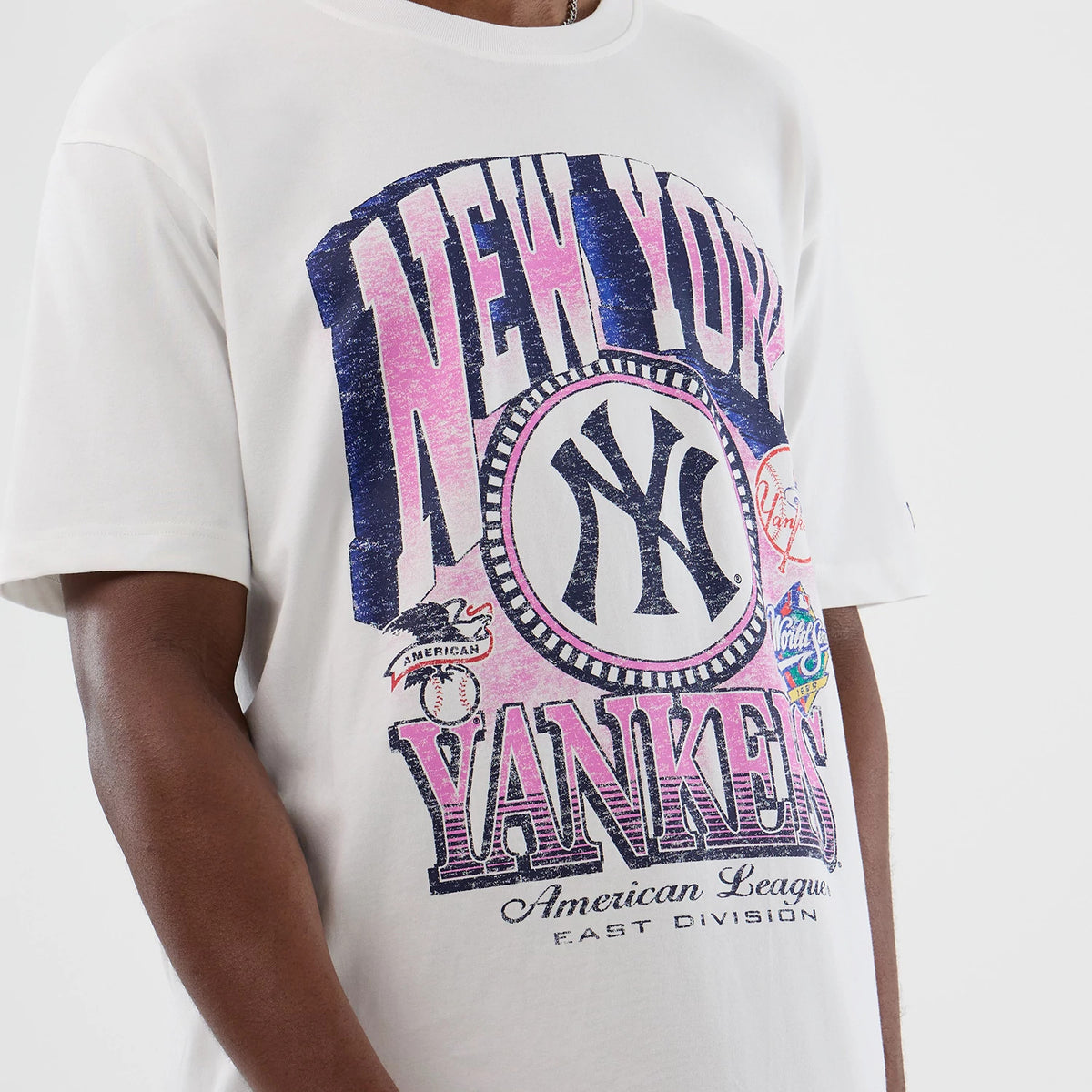 New Era New York Yankees Cooperstown MLB Sport Classic White T-Shirt, front view on-model showing a large distressed print of the New York Yankees logo and name in blue and pink with additional vintage baseball graphics across the front.