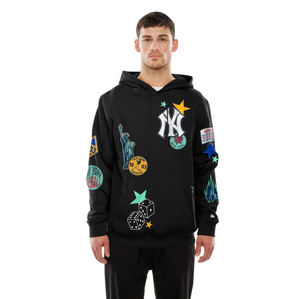 New Era New York Yankees MLB x Uptown Threads Black Pullover Hoodie, front view showing the embroidered Yankees logo on the chest, colourful patches including stars and dice across the front and sleeves, on-model styling with black trousers.